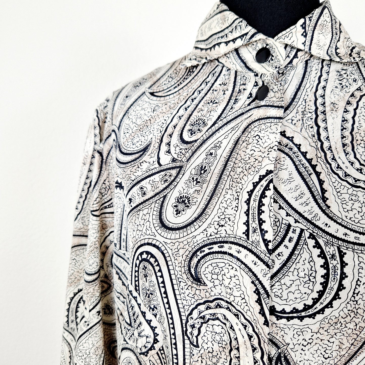 Einzigartige und nachhaltige Vintage Bluse in beige-schwarz-eierschale mit Paisley. Unique and sustainable vintage blouse in beige-black-off-white with paisley. Close-up.