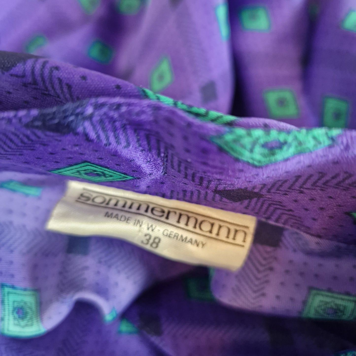Einzigartige und nachhaltige Vintage Bluse in violett-grün mit Rauten. Unique and sustainable vintage blouse in purple-green with rhombs. Tag.