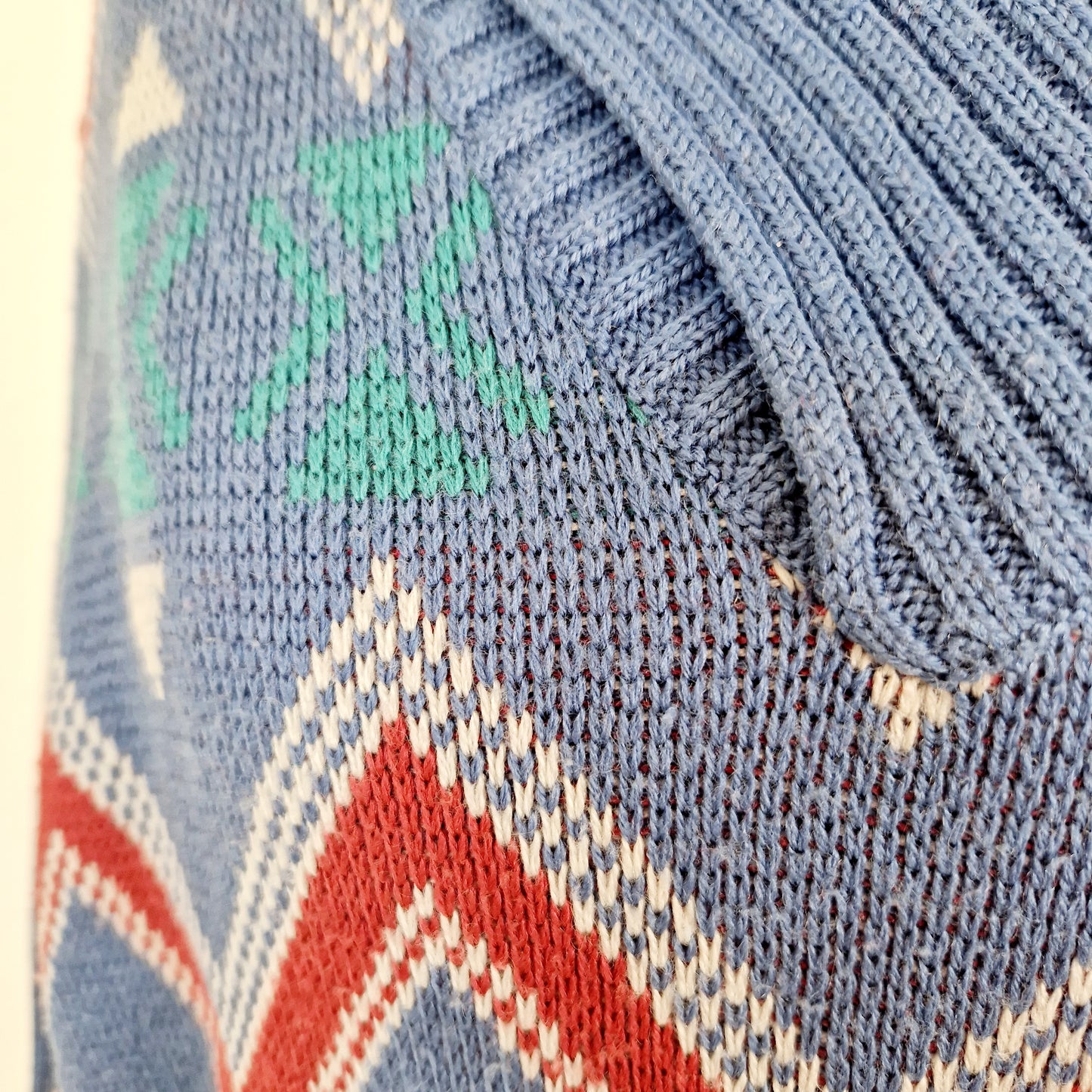 Einzigartiger und nachhaltiger Vintage Pullover in blau-rot-weiss mit Zickzack. Unique and sustainable vintage pullover in blue-red-white with zigzag. Close-up.