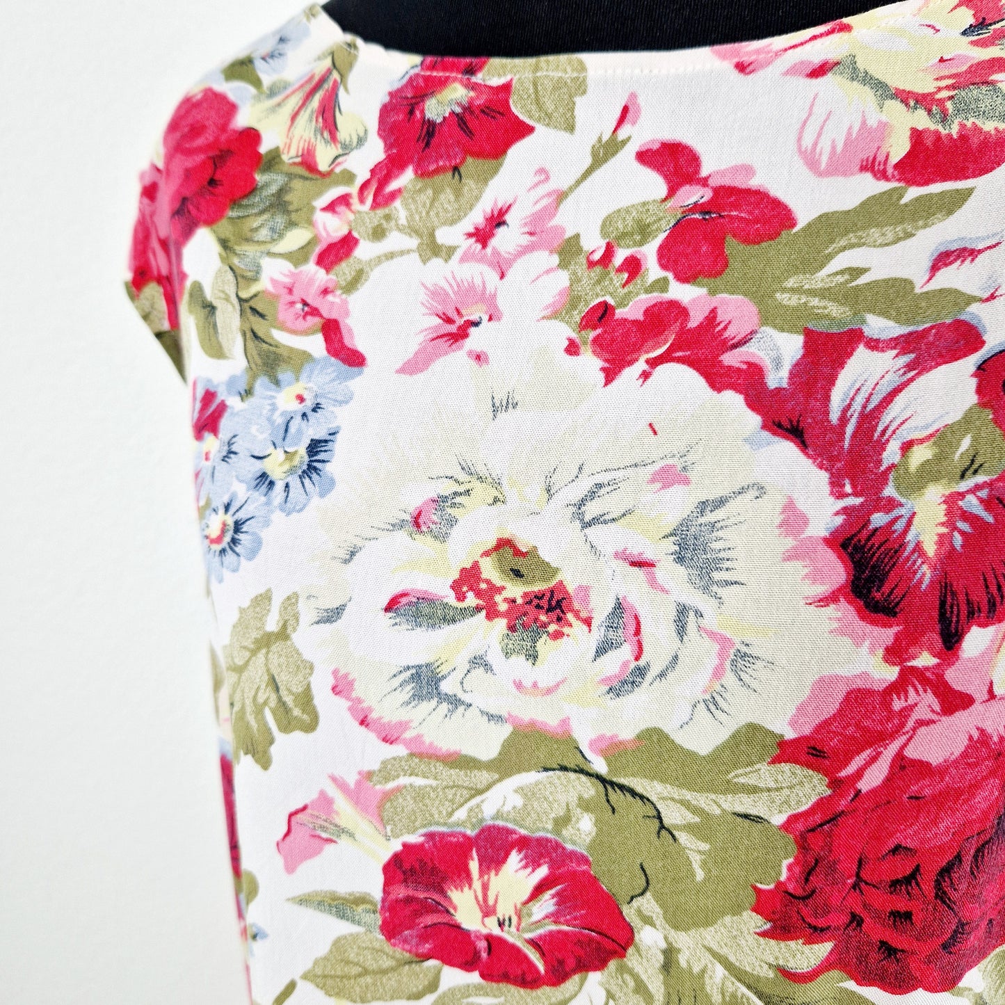 Einzigartiges und nachhaltiges Vintage Kleid, ärmellos, in weiss-rot-grün, mit Blumen. Unique and sustainable vintage dress, sleeveless, in white-red-green, with flowers. Close-up.