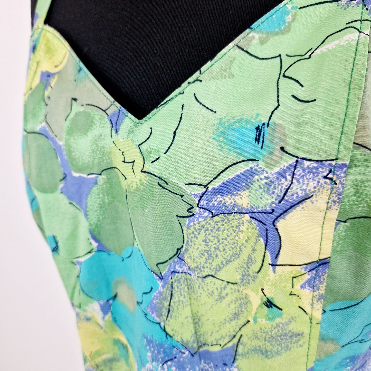Einzigartiges und nachhaltiges Vintage Kleid, Träger, in hellgrün-türkis-gelb, mit Blumen. Unique and sustainable vintage dress, straps, in light green-turquois-yellow with flowers. Close-up.