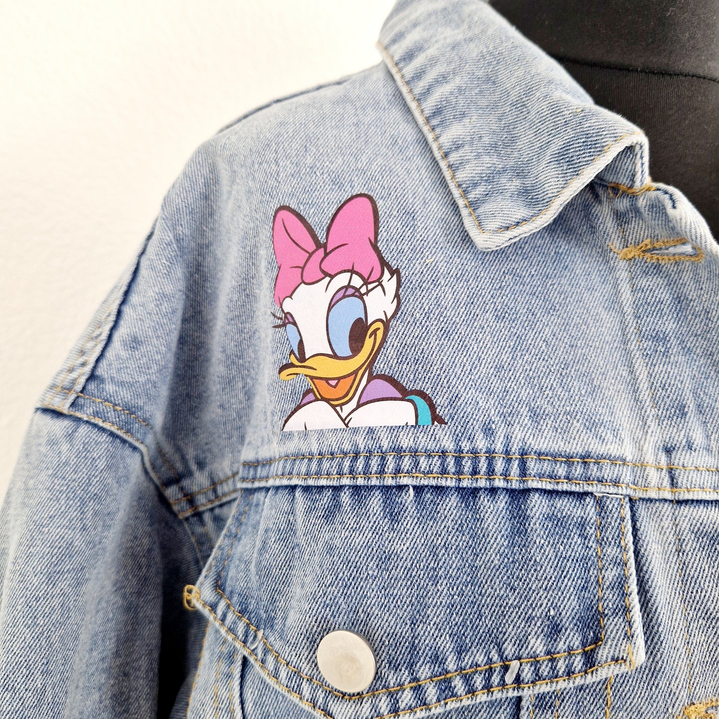 Einzigartige und nachhaltige Vintage Jeansjacke mit Daisy Duck. Unique and sustainable vintage jeans jacket with daisy duck. Close-up.