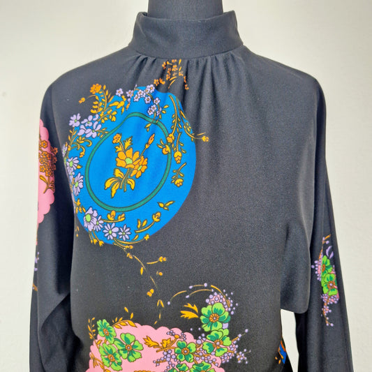 Einzigartiges und nachhaltiges Vintage Kleid in schwarz mit Blumen und Kreisen. Unique and sustainable vintage dress in black with flowers and circles. Close-up.