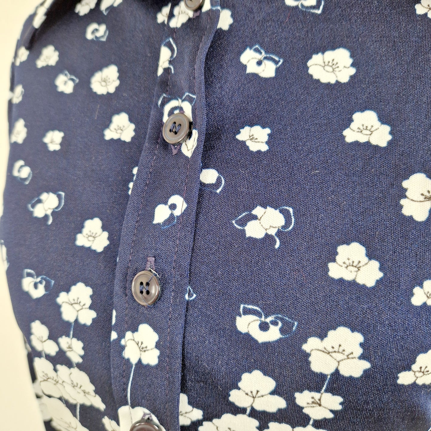 Einzigartige und nachhaltige Vintage Bluse in dunkelblau-weiss mit Blumen. Unique and sustainable vintage blouse in dark blue-white with flowers. Close-up.
