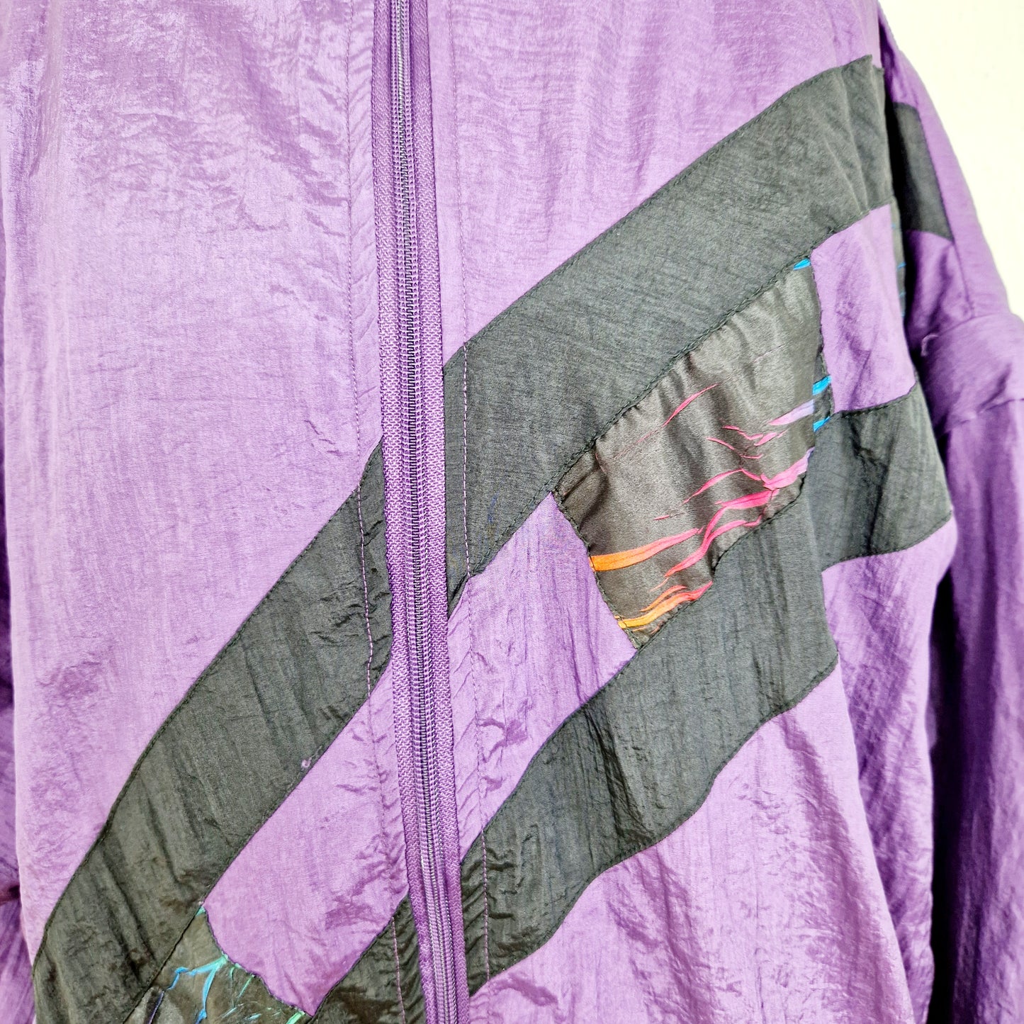 Einzigartige und nachhaltige Vintage Trainerjacke in violett. Unique and sustainable vintage track jacket in purple. Close-up.