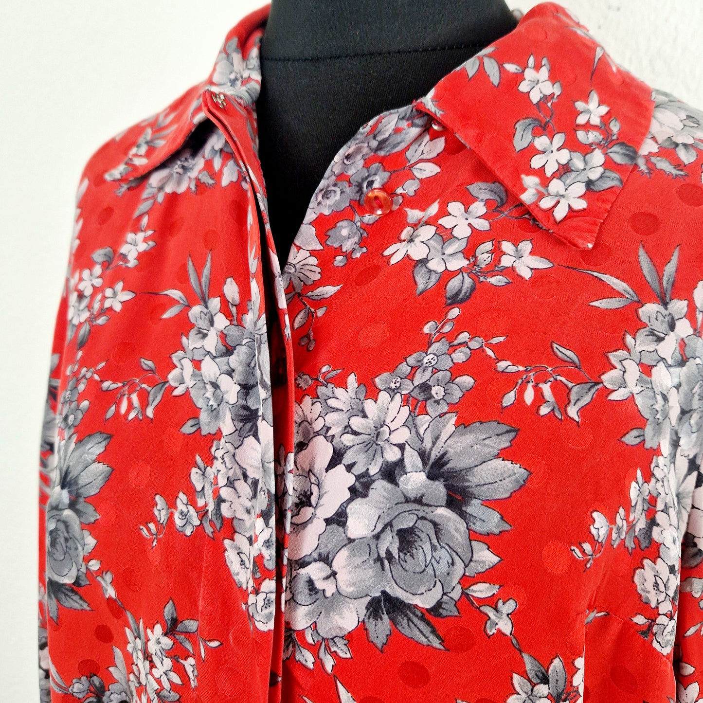 Einzigartige und nachhaltige Vintage Bluse in rot-grau mit Blumen. Unique and sustainable vintage blouse in red-grey with flowers. Close-up.