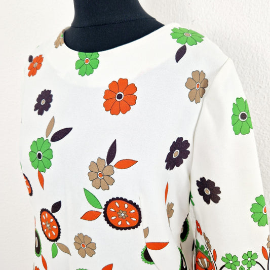 Einzigartiges und nachhaltiges Vintage Shirt in eierschale-orange-grün mit Blumen und 3/4-Ärmeln. Unique and sustainable vintage shirt in off white-orange-green with flowers and 3/4-sleeves. Close-up.