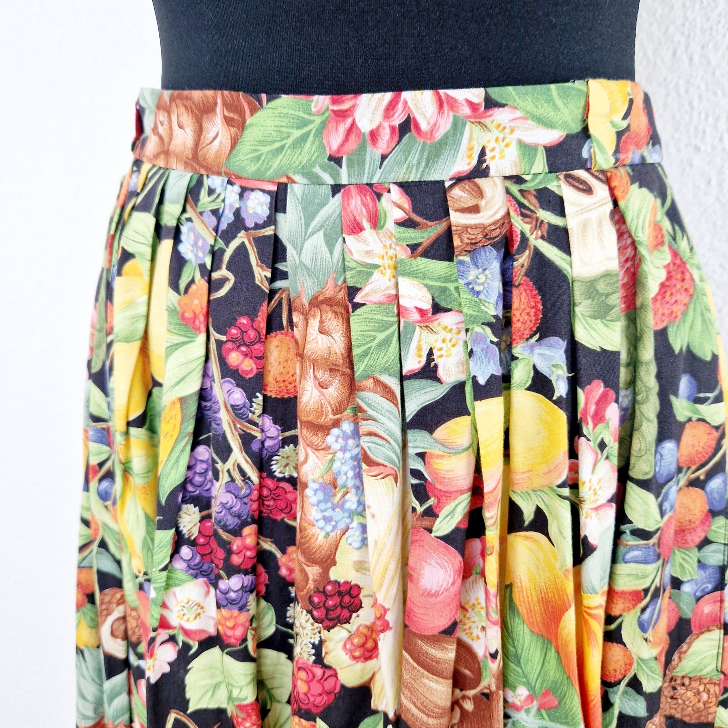 Einzigartiger und nachhaltiger Vintage Rock in schwarz-gelb-rot mit Früchten. Unique and sustainable vintage skirt in black-yellow-red with fruit. Close-up.