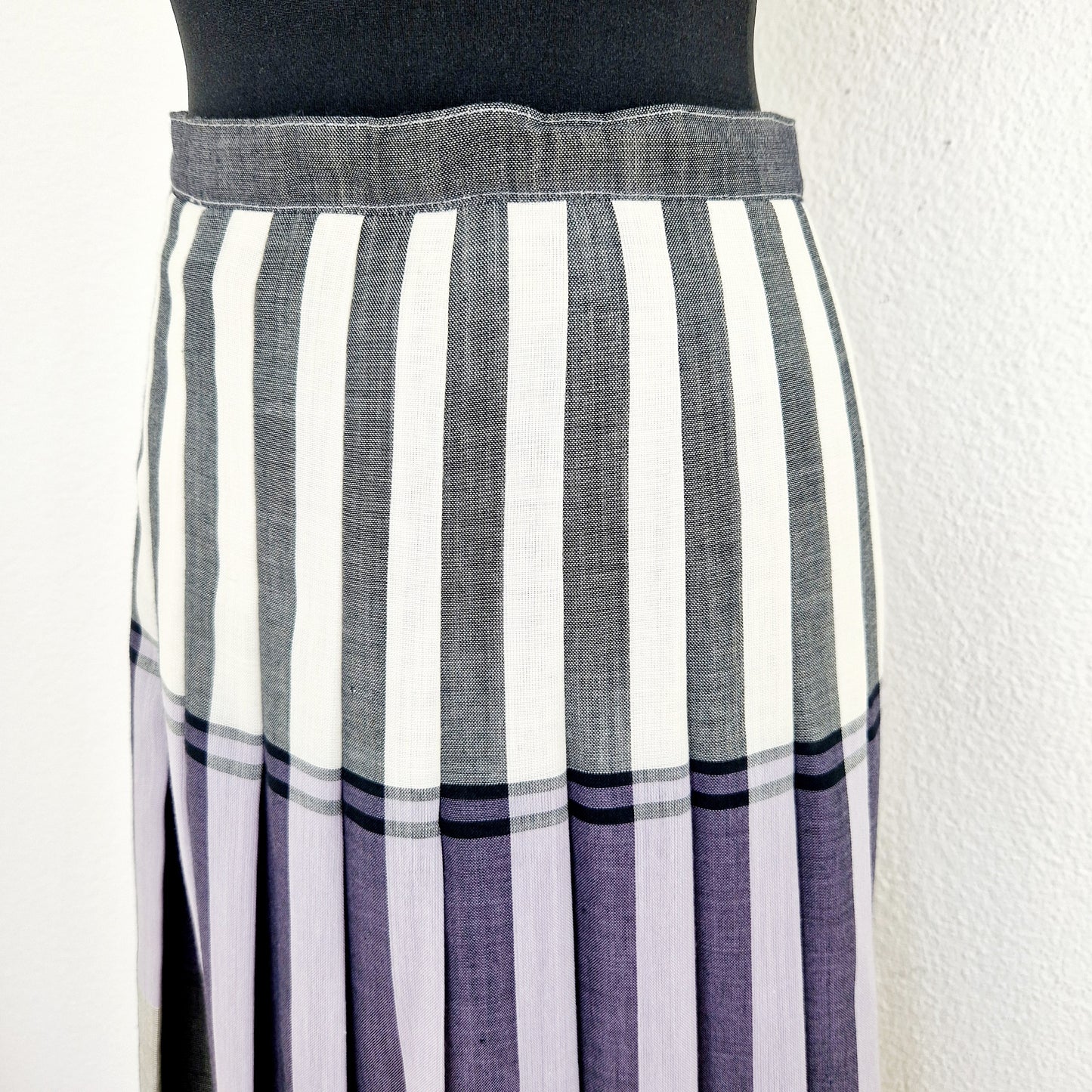 Einzigartiger und nachhaltiger Vintage Rock in weiss-lila-hellblau mit Falten. Unique and sustainable vintage skirt in white-purple-light blue with pleats. Close-up.