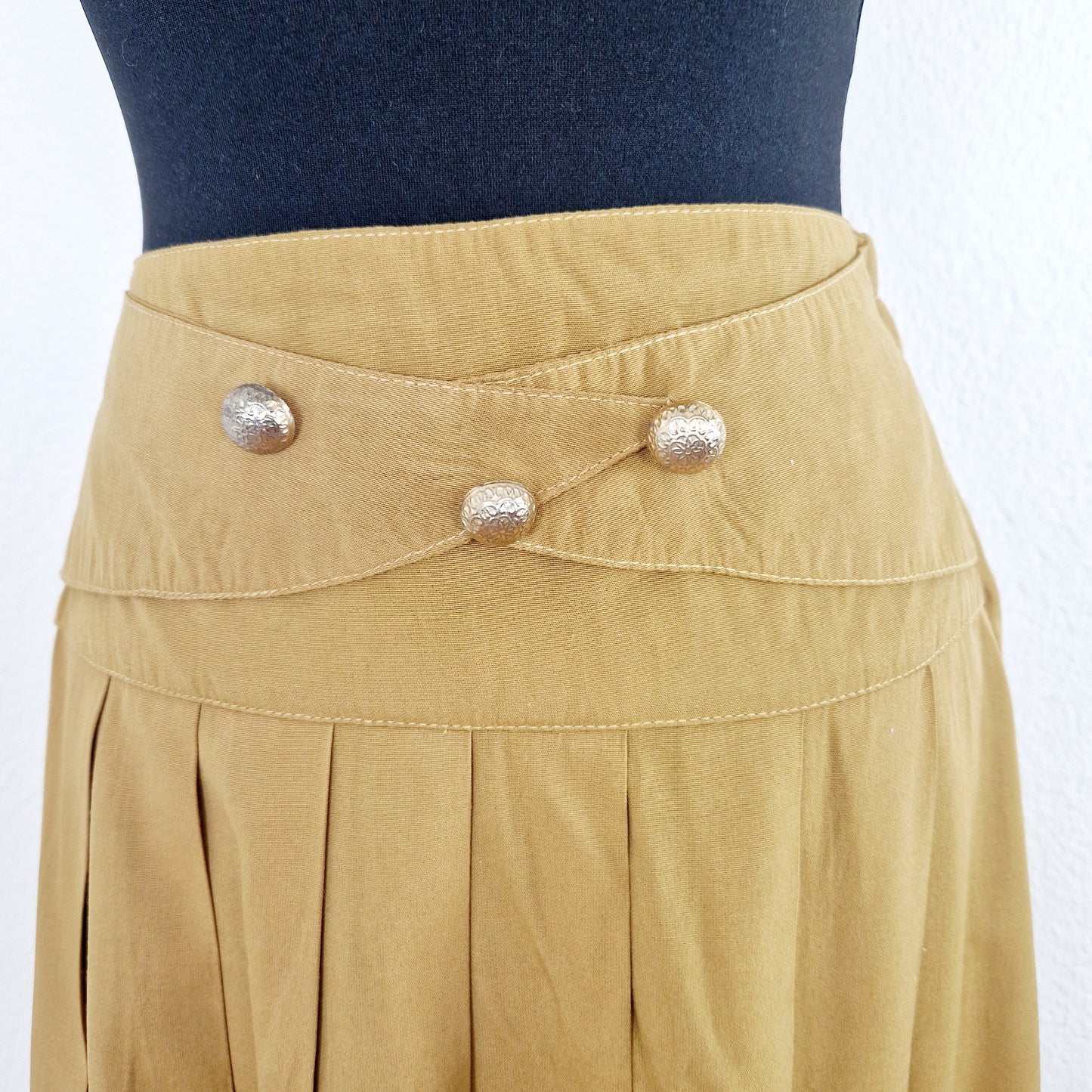 Einzigartiger und nachhaltiger Vintage Rock in senfgelb. Unique and sustainable vintage skirt in mustard yellow. Close-up.