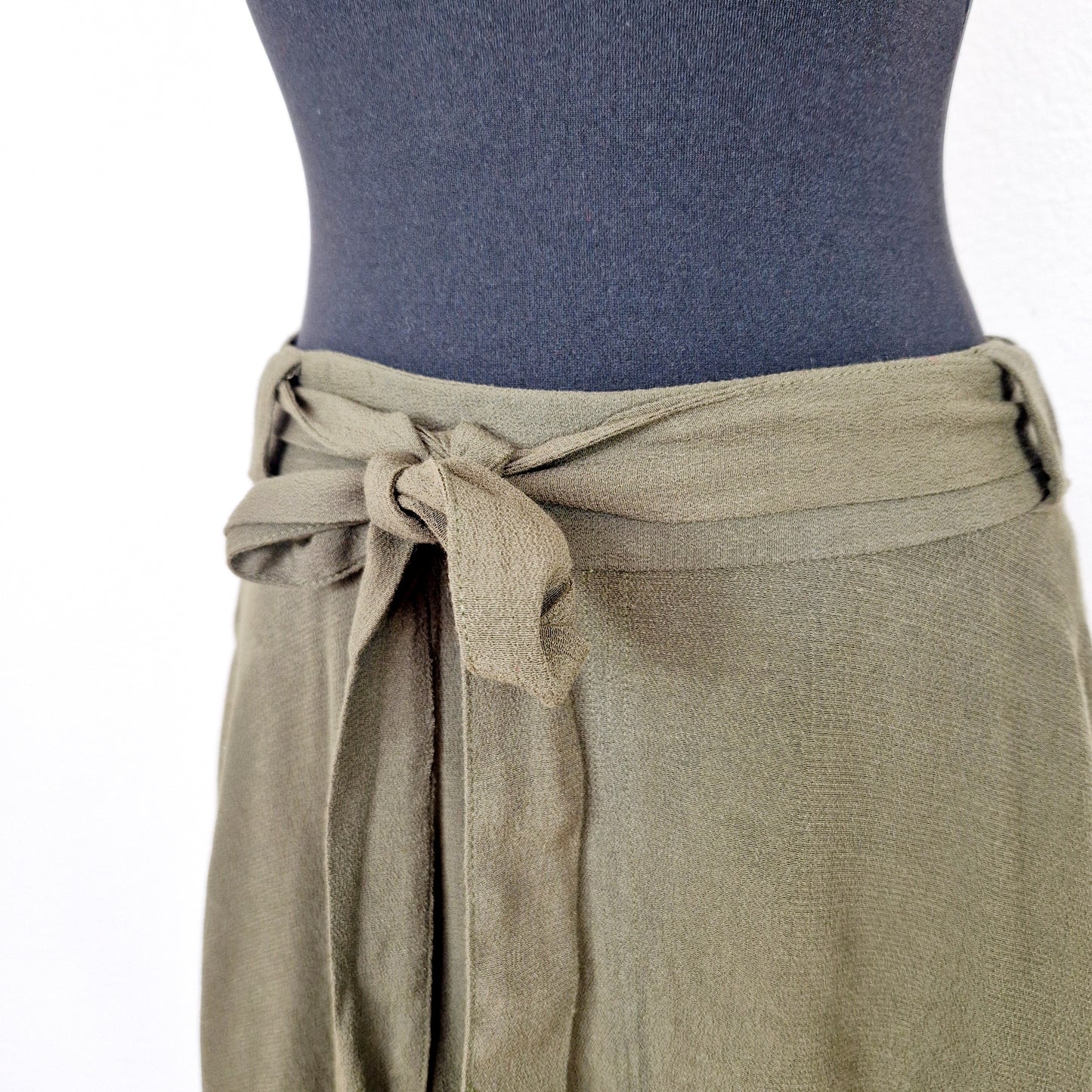 Einzigartiger und nachhaltiger Vintage Rock in oliv mit Gürtel. Unique and sustainable vintage skirt in oliv with belt. Close-up.