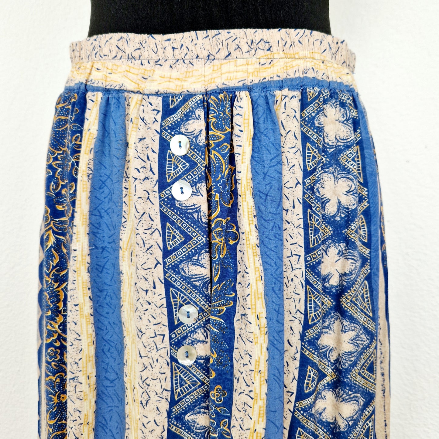 Einzigartiger und nachhaltiger Vintage Rock in sand-blau-senfgelb mit Streifen und Blumen. Unique and sustainable vintage skirt in sand-blue-mustard yellow with stripes and flowers. Close-up.