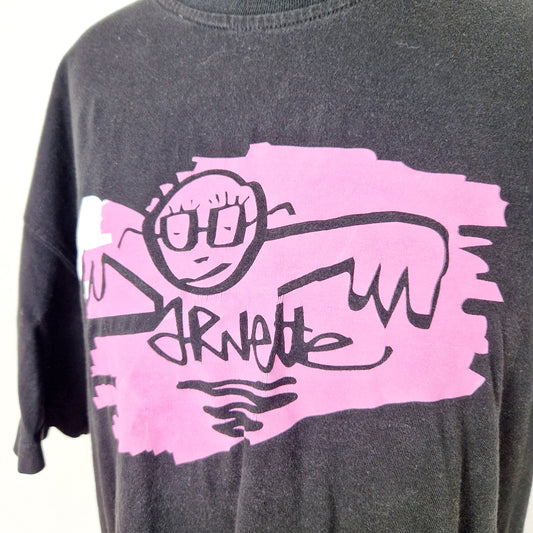 Einzigartiges und nachhaltiges Vintage T-Shirt in schwarz-pink-weiss mit einer Person mit Brille. Close-up.