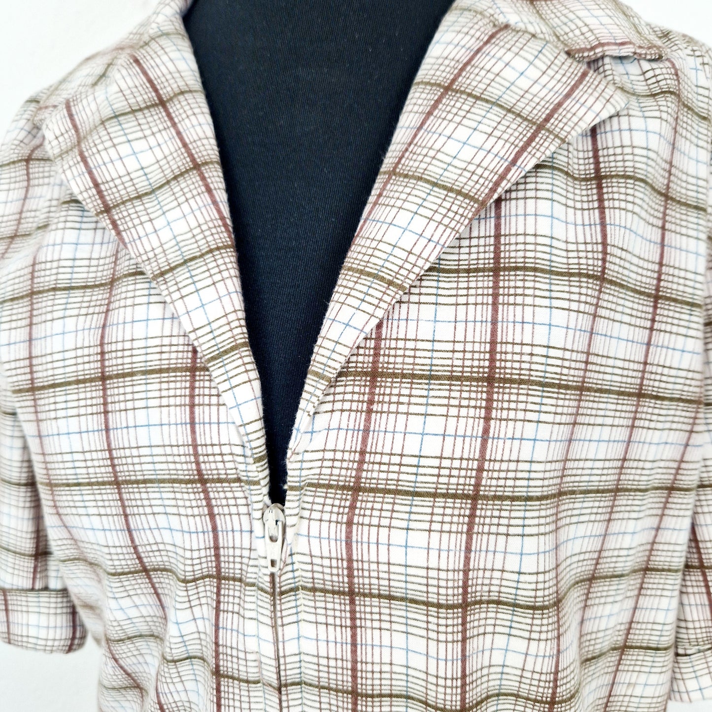 Einzigartiges und nachhaltiges Vintage Kleid, Kurzarm, in weiss-braun-blau, kariert. Unique and sustainable vintage dress, shortsleeved, in white-brown-blue, checked. Close-up.