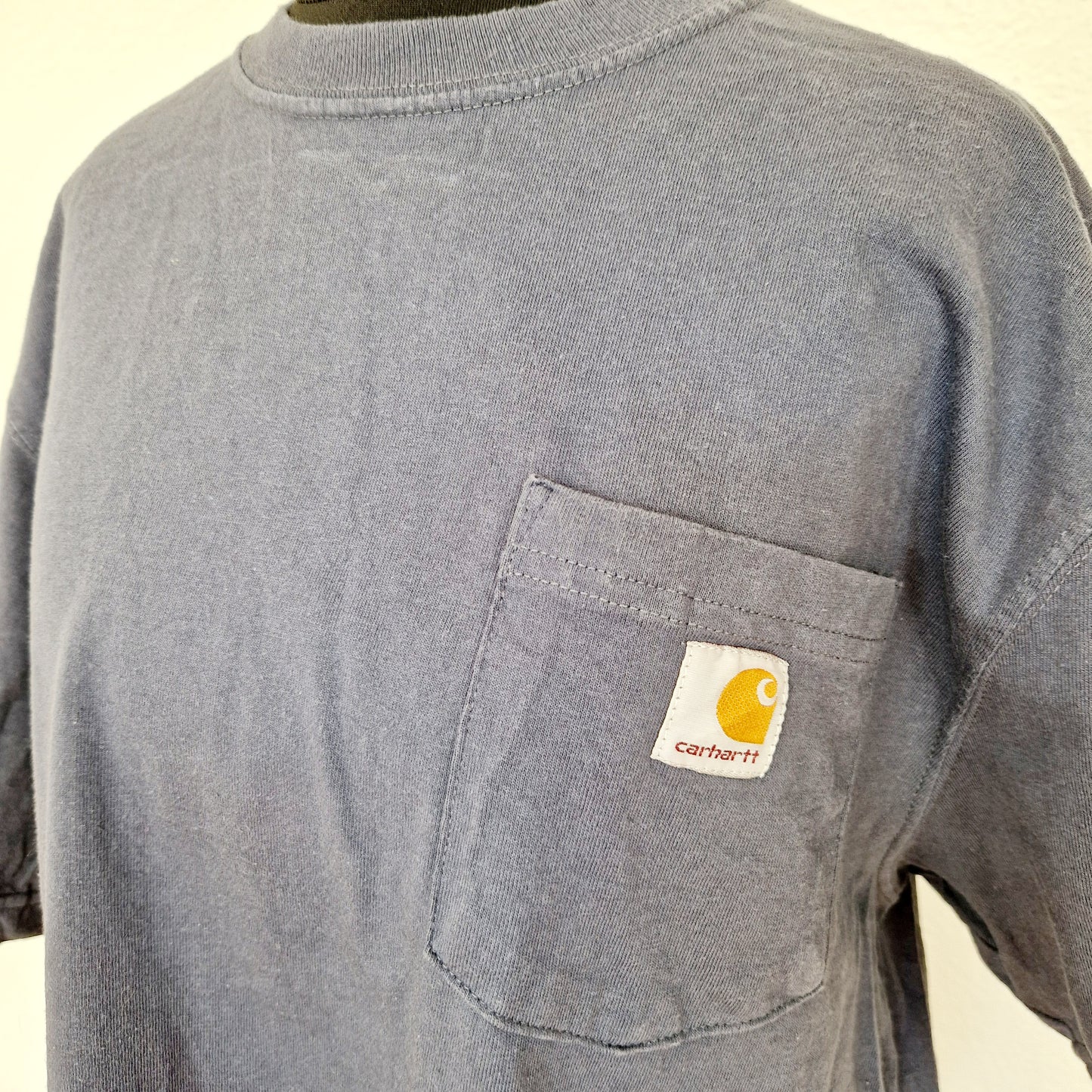 Einzigartiges und nachhaltiges Vintage T-Shirt in blaugrau von Carhartt. Unique and sustainable vintage t-shirt in blue grey from Carhartt. Close-up.