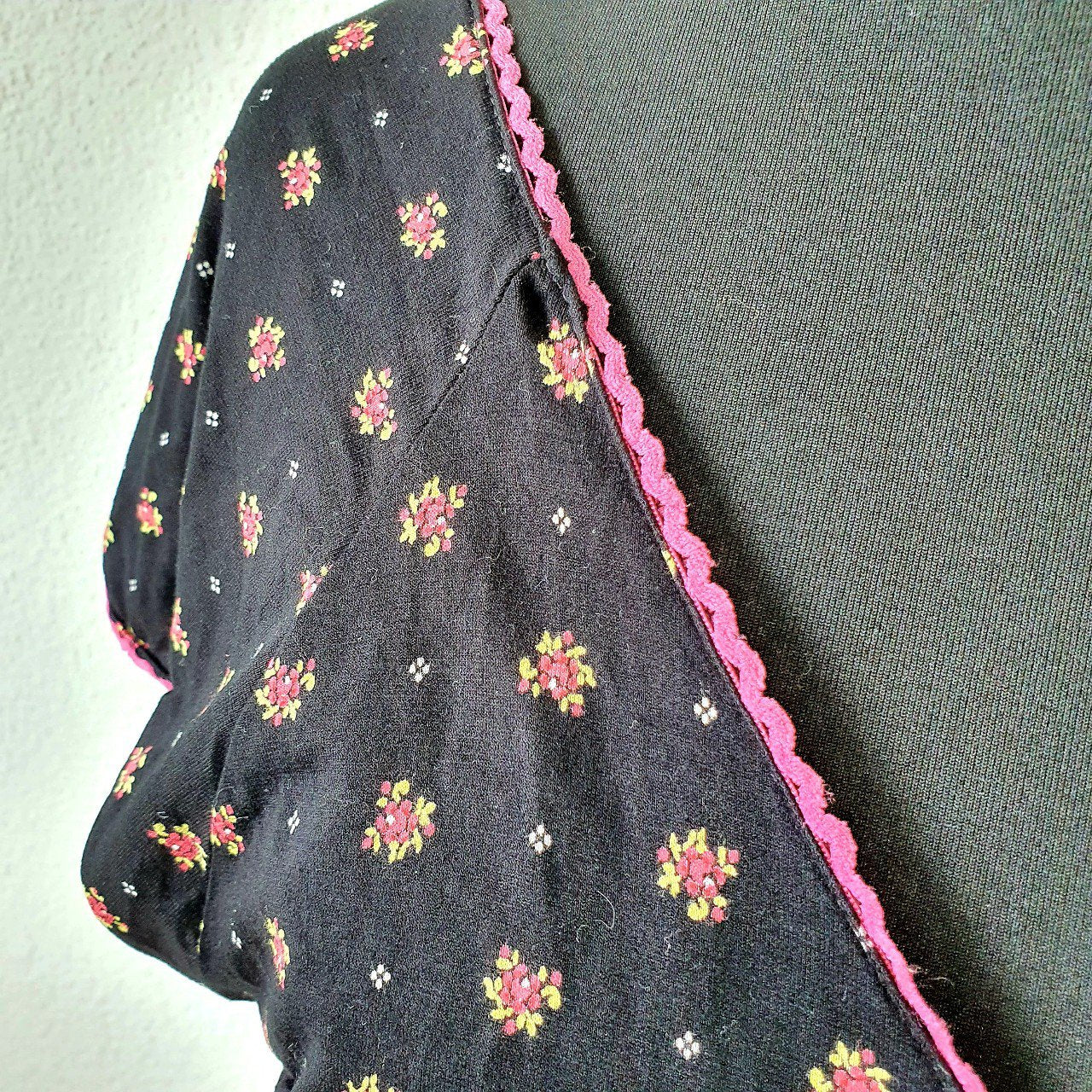 Einzigartiges und nachhaltiges Vintage Kleid in schwarz mit Blumen. Unique and sustainable vintage dress in black with flowers. Close-up.