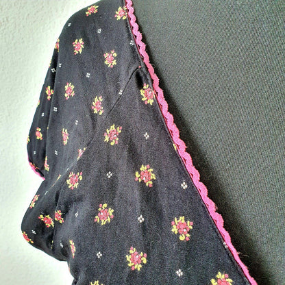 Einzigartiges und nachhaltiges Vintage Kleid in schwarz mit Blumen. Unique and sustainable vintage dress in black with flowers. Close-up.