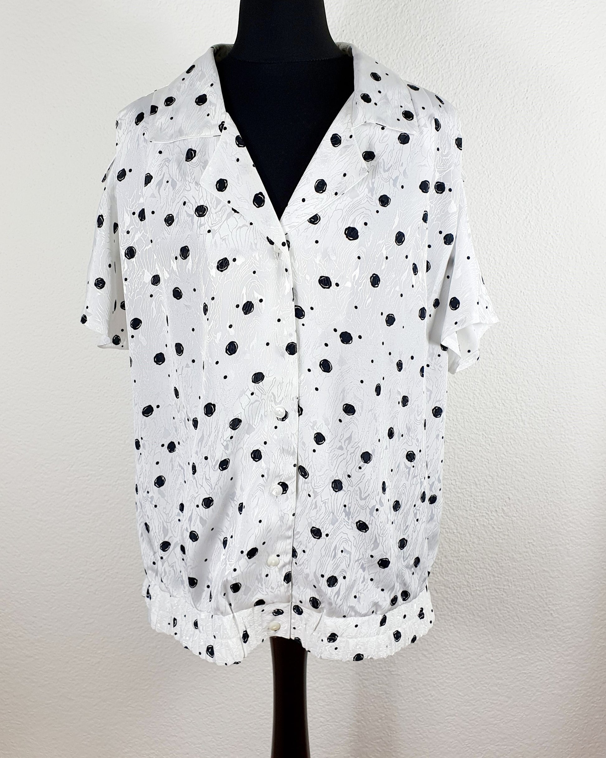 Einzigartige und nachhaltige Vintage Bluse in weiss-schwarz mit Punkten. Unique and sustainable vintage blouse in white-black with polka dots. Front.