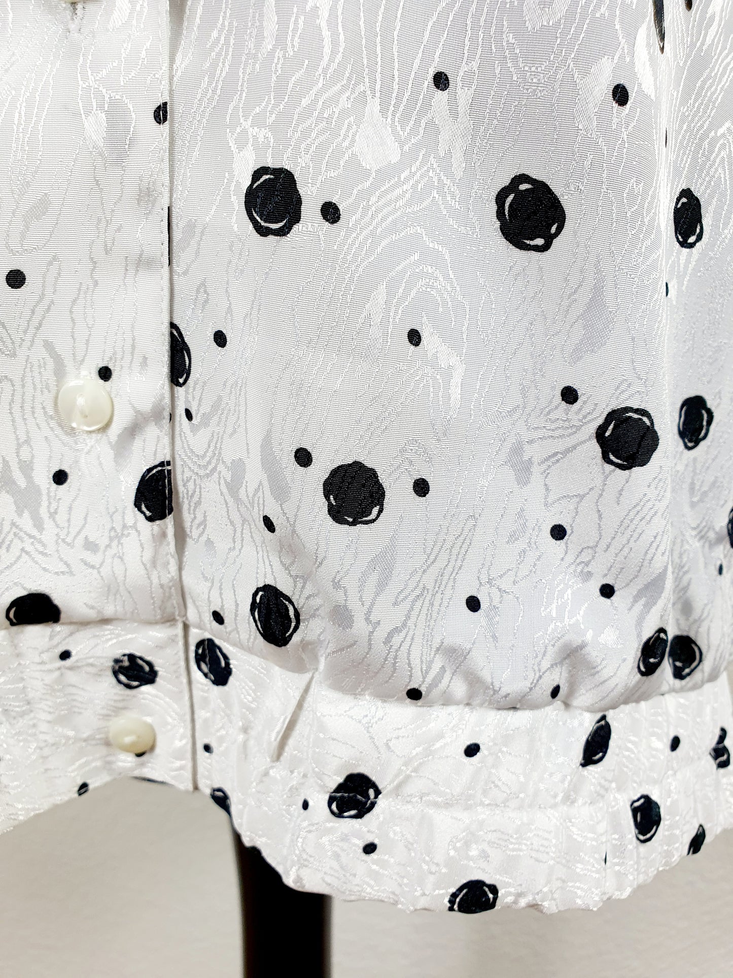 Einzigartige und nachhaltige Vintage Bluse in weiss-schwarz mit Punkten. Unique and sustainable vintage blouse in white-black with polka dots. Close-up.