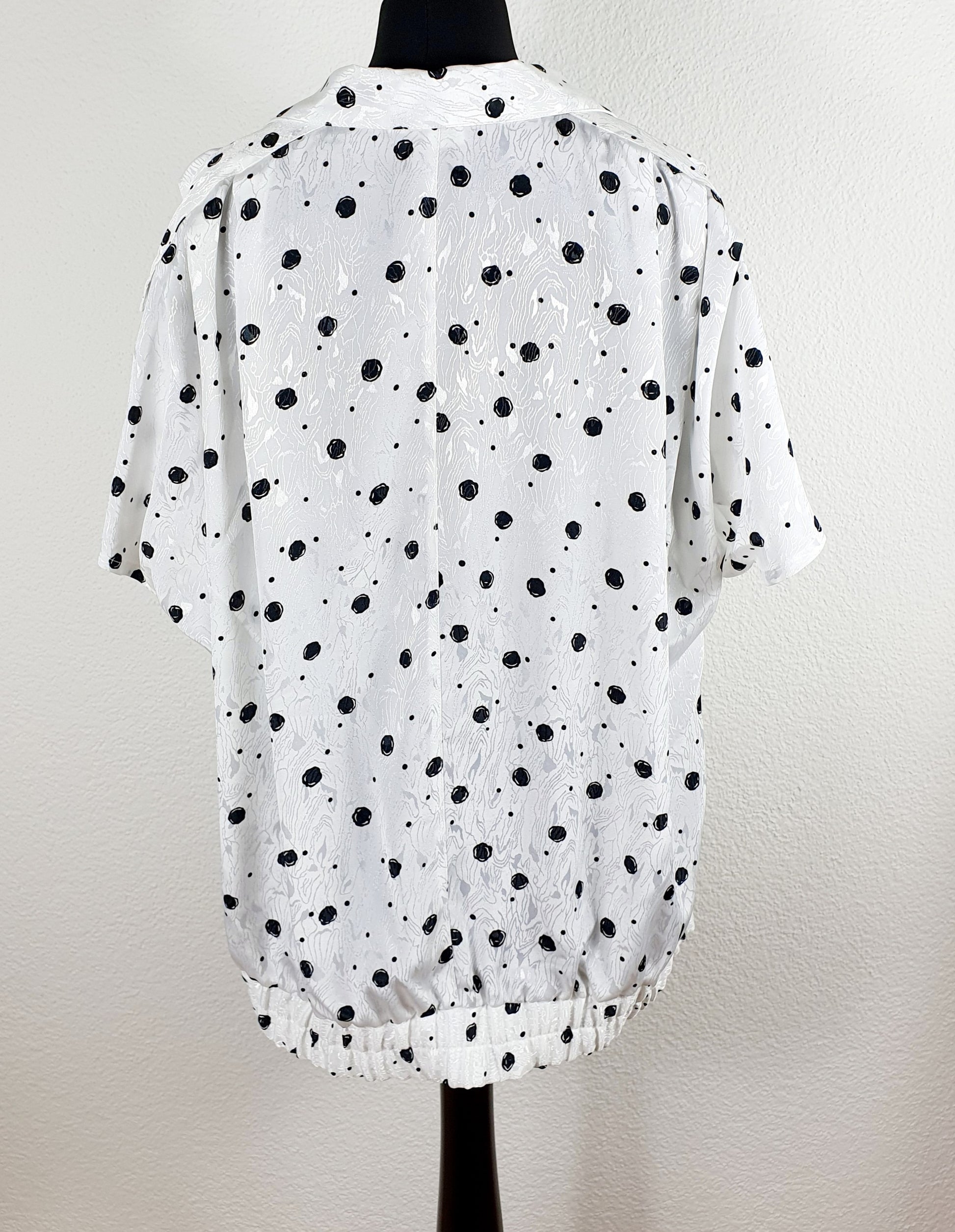 Einzigartige und nachhaltige Vintage Bluse in weiss-schwarz mit Punkten. Unique and sustainable vintage blouse in white-black with polka dots. Back.