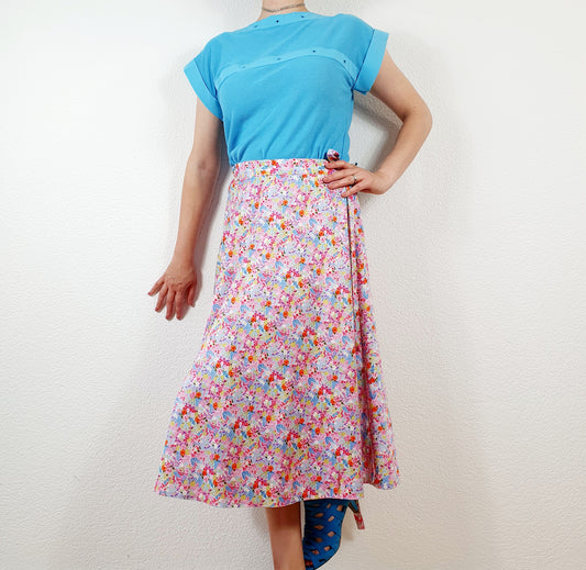 Einzigartiger und nachhaltiger Vintage Wickelrock in rosa-hellblau-hellgrün mit Blumen. Unique and sustainable vintage wrap skirt in pink-light blue-light green with flowers. Model.