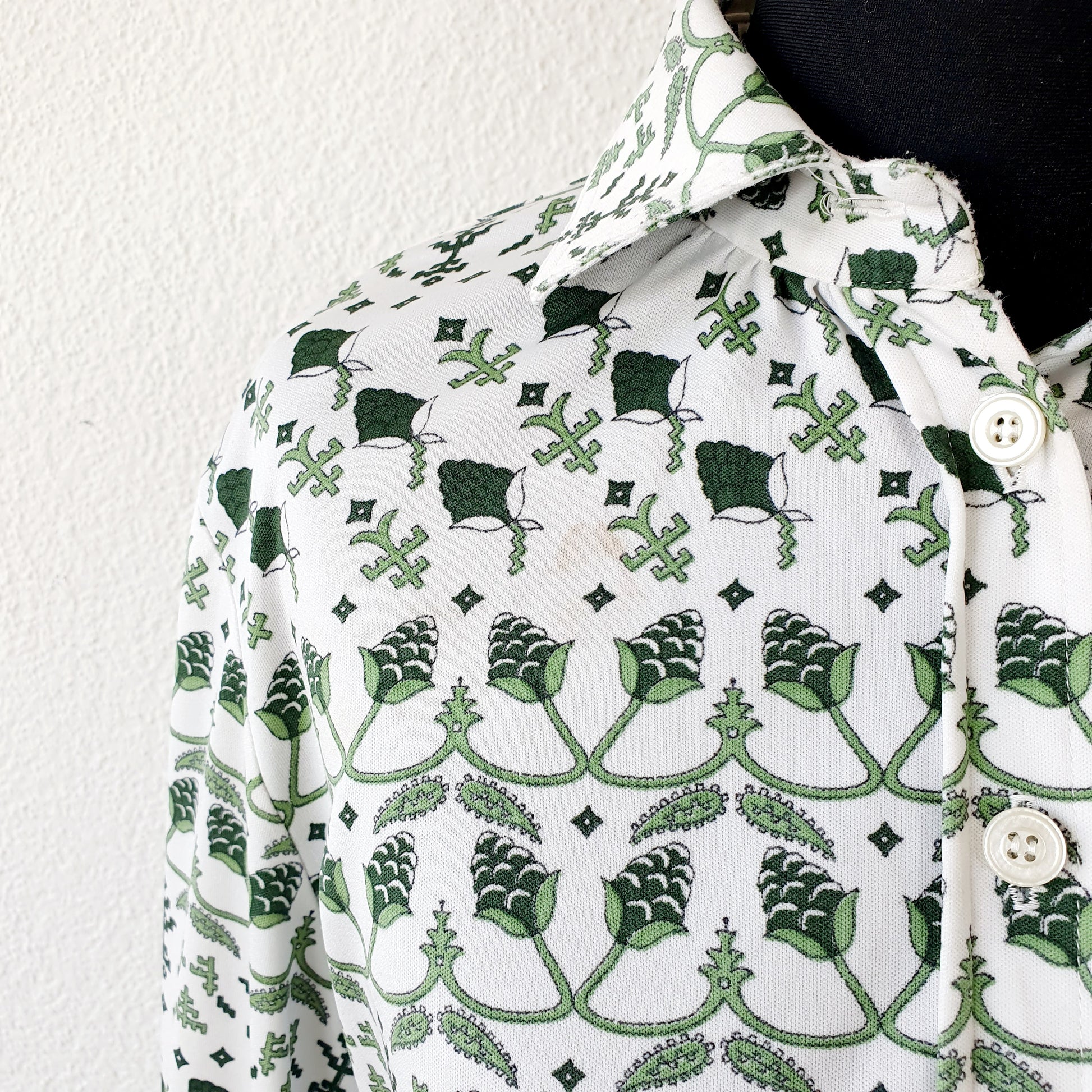 Einzigartige und nachhaltige Vintage Bluse in grün-weiss mit Pflanzen. Unique and sustainable vintage blouse in green-white with plants. Close-up.