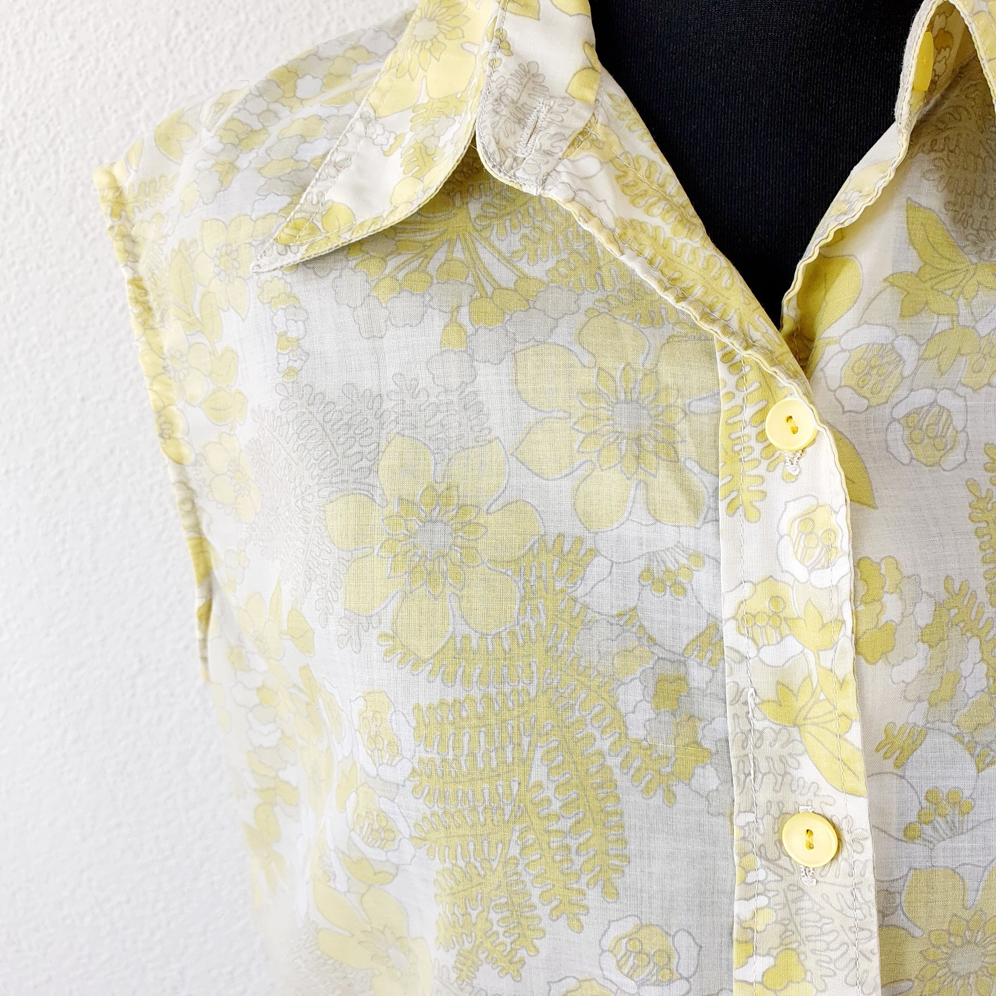 Einzigartige und nachhaltige Vintage Bluse in gelb-weiss mit Blumen. Unique and sustainable vintage blouss in yellow-white with flowers. Close-up.