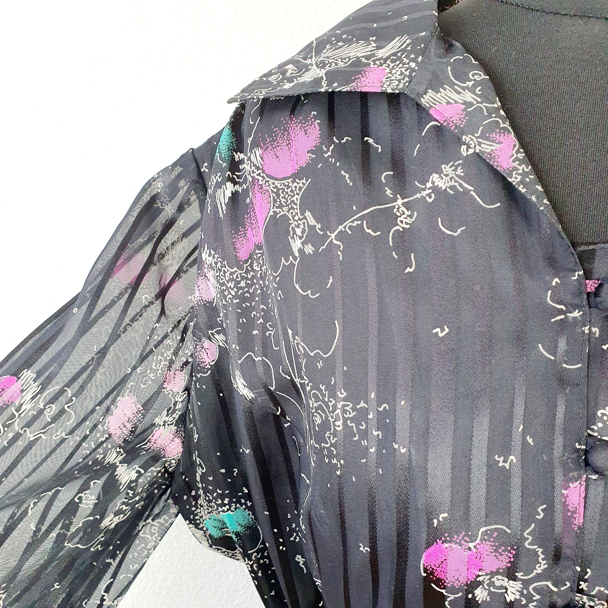 Einzigartiges und nachhaltiges Vintage Kleid in schwarz mit Blumen. Unique and sustainable Vintage dress in black with flowers. Close-up.