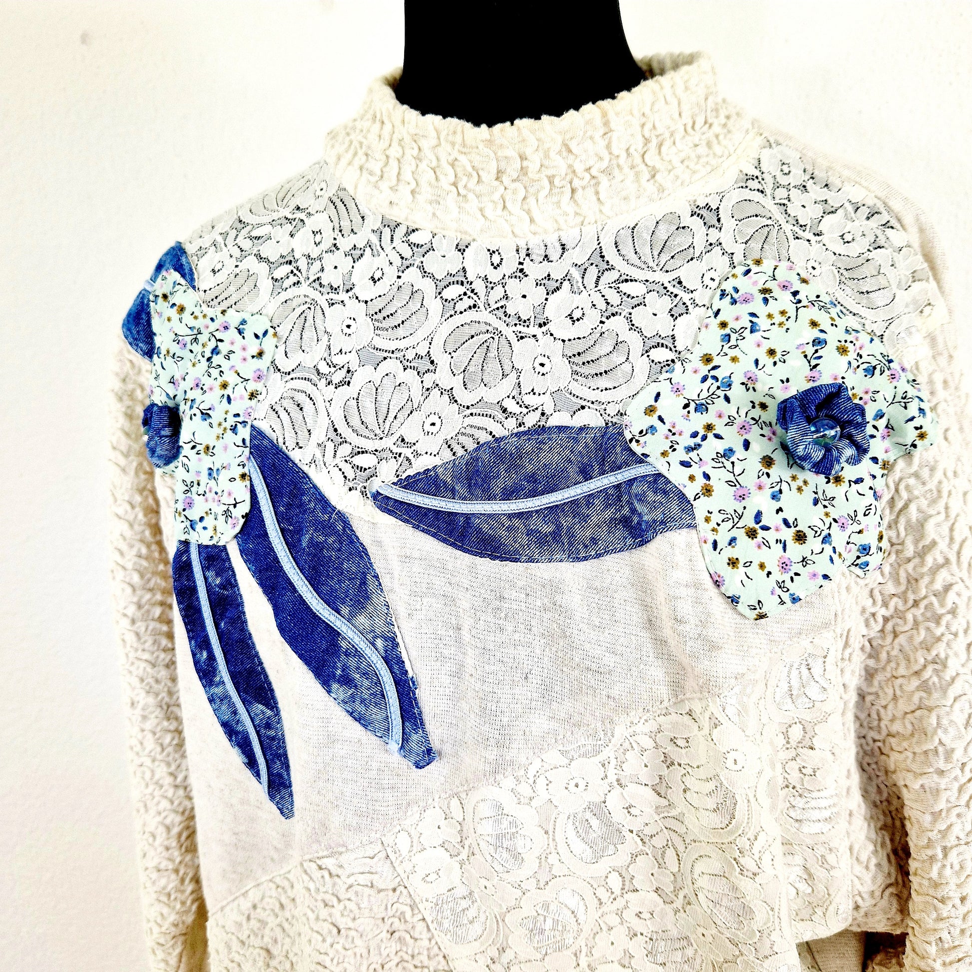 Einzigartiger und nachhaltiger Vintage Pullover in beige-blau mit Blumen. Unique and sustainable vintage pullover in beige-blue with flowers. Close-up.