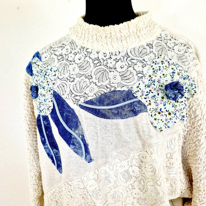 Einzigartiger und nachhaltiger Vintage Pullover in beige-blau mit Blumen. Unique and sustainable vintage pullover in beige-blue with flowers. Close-up.