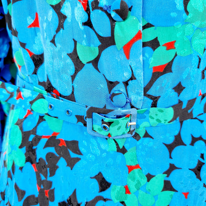 Einzigartiges und nachhaltiges Vintage Kleid in blau-grün-rot mit Blättern. Unique and sustainable vintage dress in blue-green-red with leaves. Close-up.