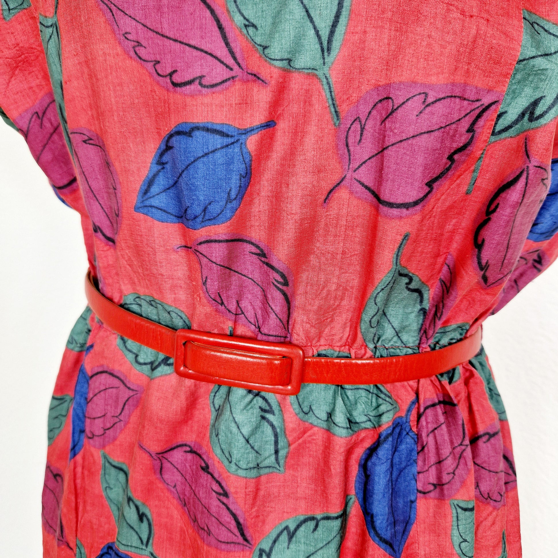 Einzigartiges und nachhaltiges Vintage Kleid in rot mit Blättern. Unique and sustainable vintage dress in red with leaves. Close-up.
