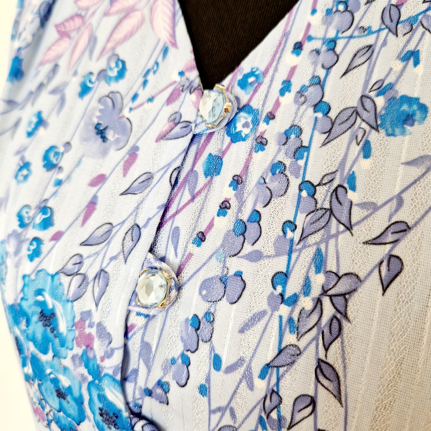 Einzigartiges und nachhaltiges Vintage Kleid in blau mit Blumen. Unique and sustainable vintage dress in blue with flowers. Close-up.