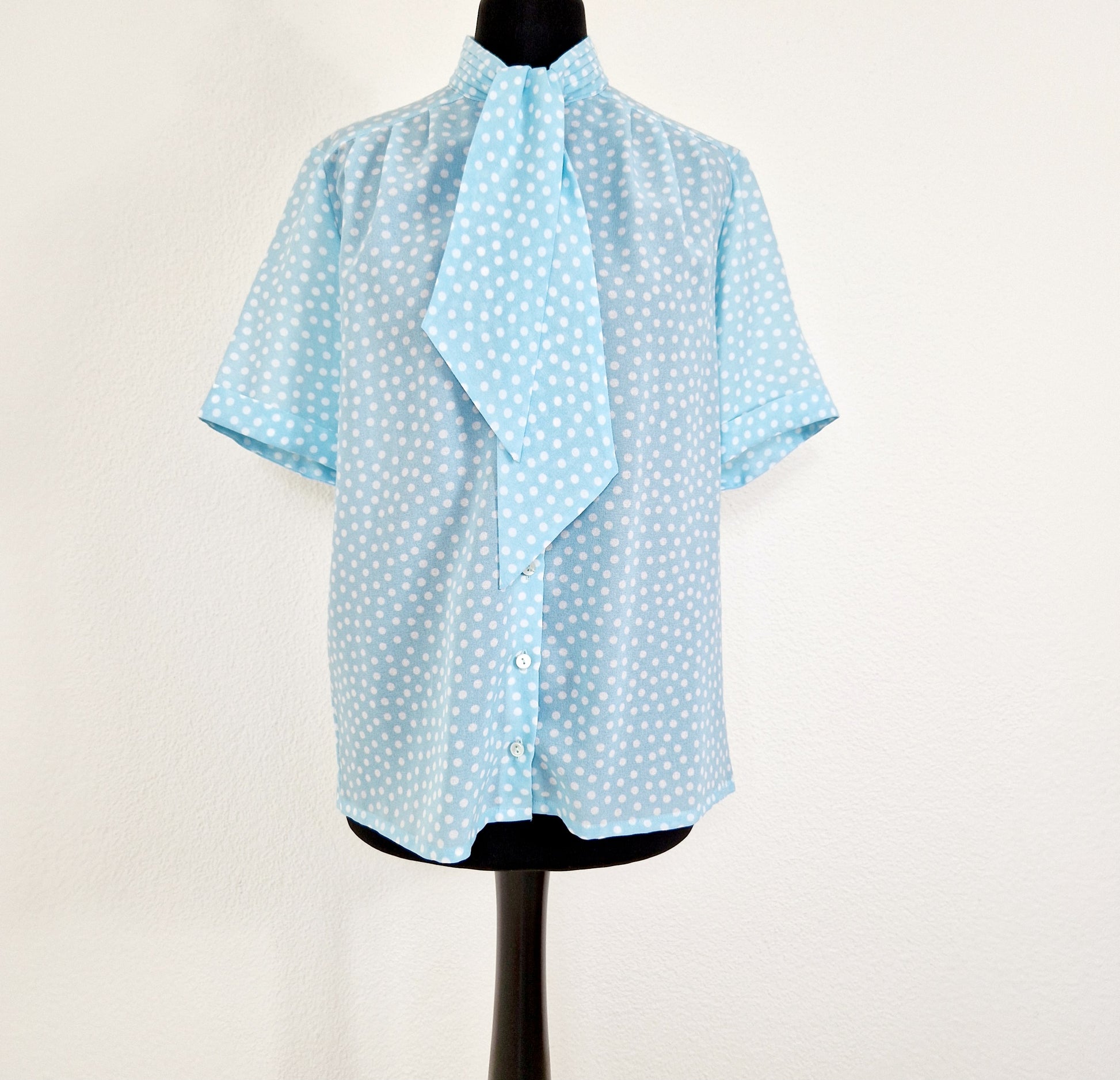 Einzigartige und nachhaltige Vintage Bluse in hellblau mit Punkten. Unique and sustainable vintage blouse in light blue with polka dots. Front.