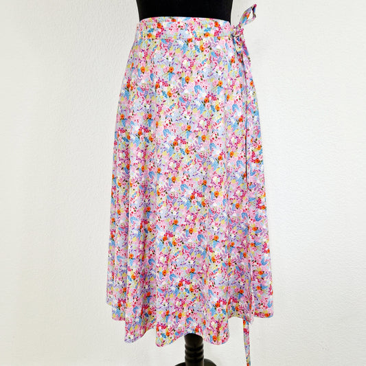 Einzigartiger und nachhaltiger Vintage Wickelrock in rosa-hellblau-hellgrün mit Blumen. Unique and sustainable vintage wrap skirt in pink-light blue-light green with flowers. Front.