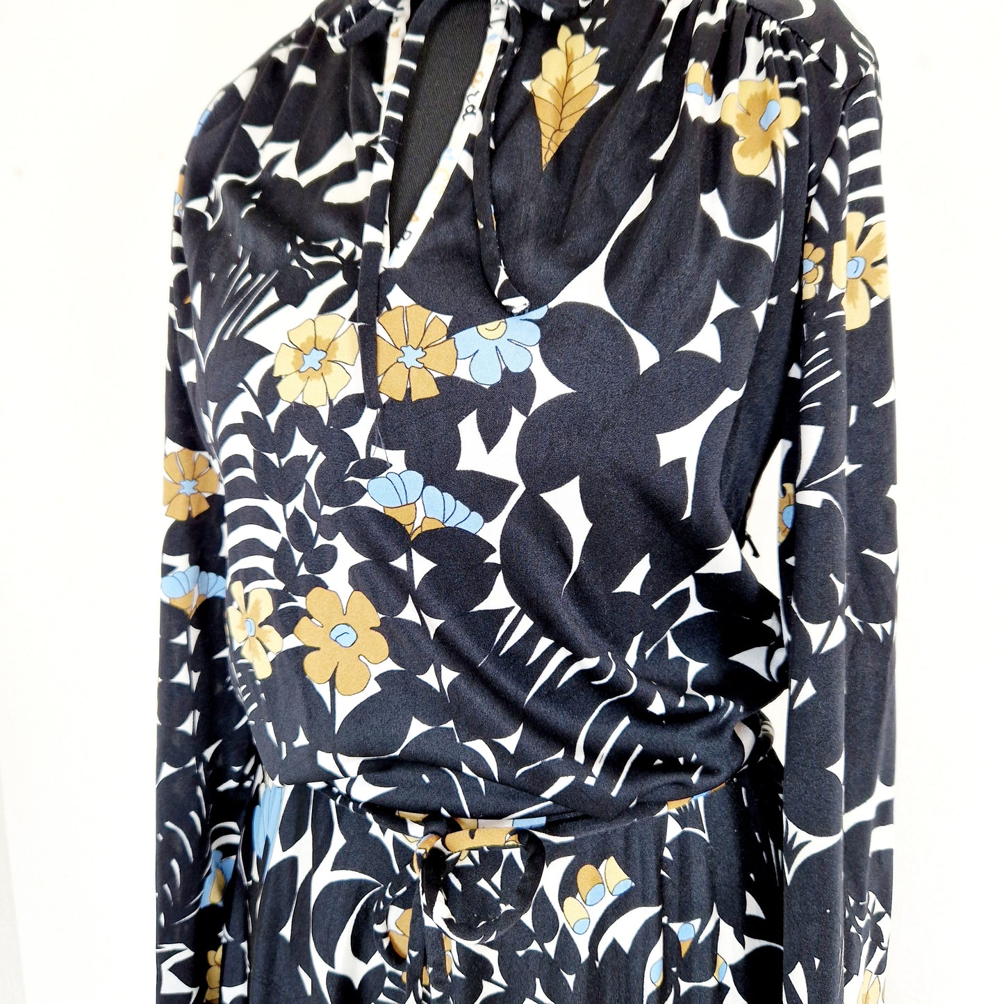 Einzigartiges und nachhaltiges Vintage Kleid in schwarz-beige-blau mit Blumen. Unique and sustainable vintage dress in black-beige-blue with flowers. Close-up.