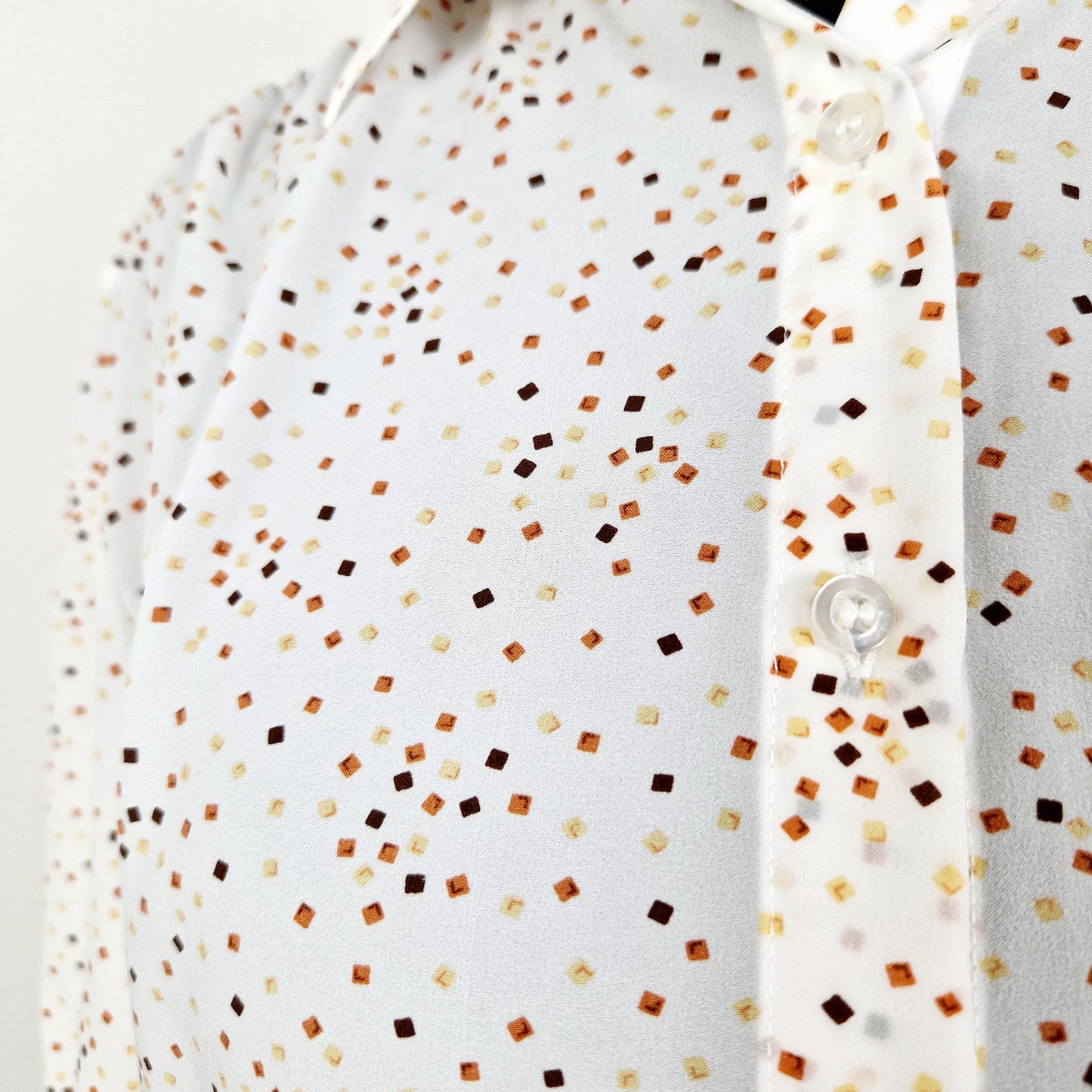 Einzigartige und nachhaltige Vintage Bluse in weiss mit Vierecken. Unique and sustainable vintage blouse in white with squares. Close-up.