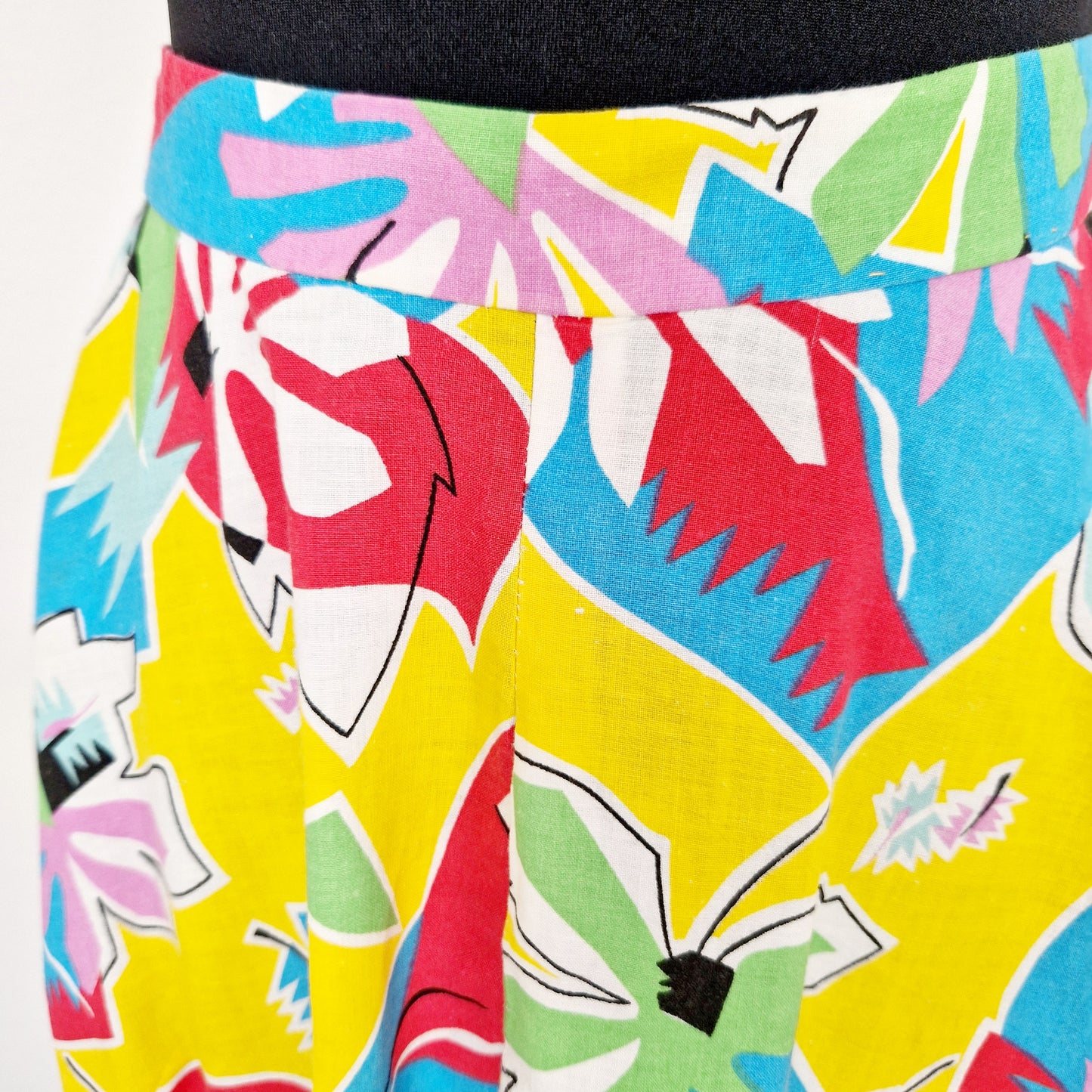 Einzigartiger und nachhaltiger Vintage Rock in gelb-türkis-lila. Unique and sustainable vintage skirt in yellow-turquoise-purple. Close-up.