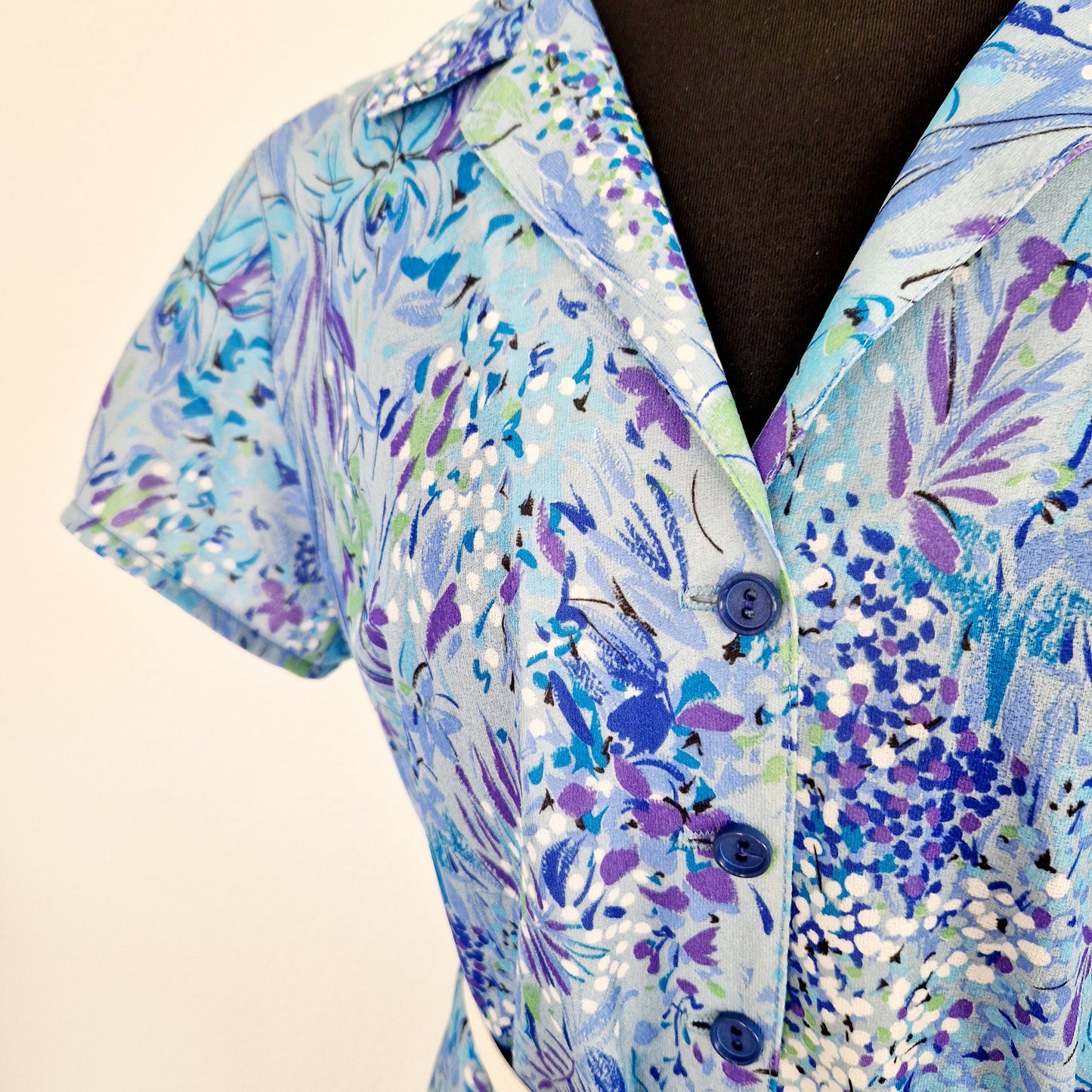 Einzigartiges und nachhaltiges Vintage Kleid in blau mit Blumen. Unique and sustainable vintage dress in blue with flowers. Close-up.