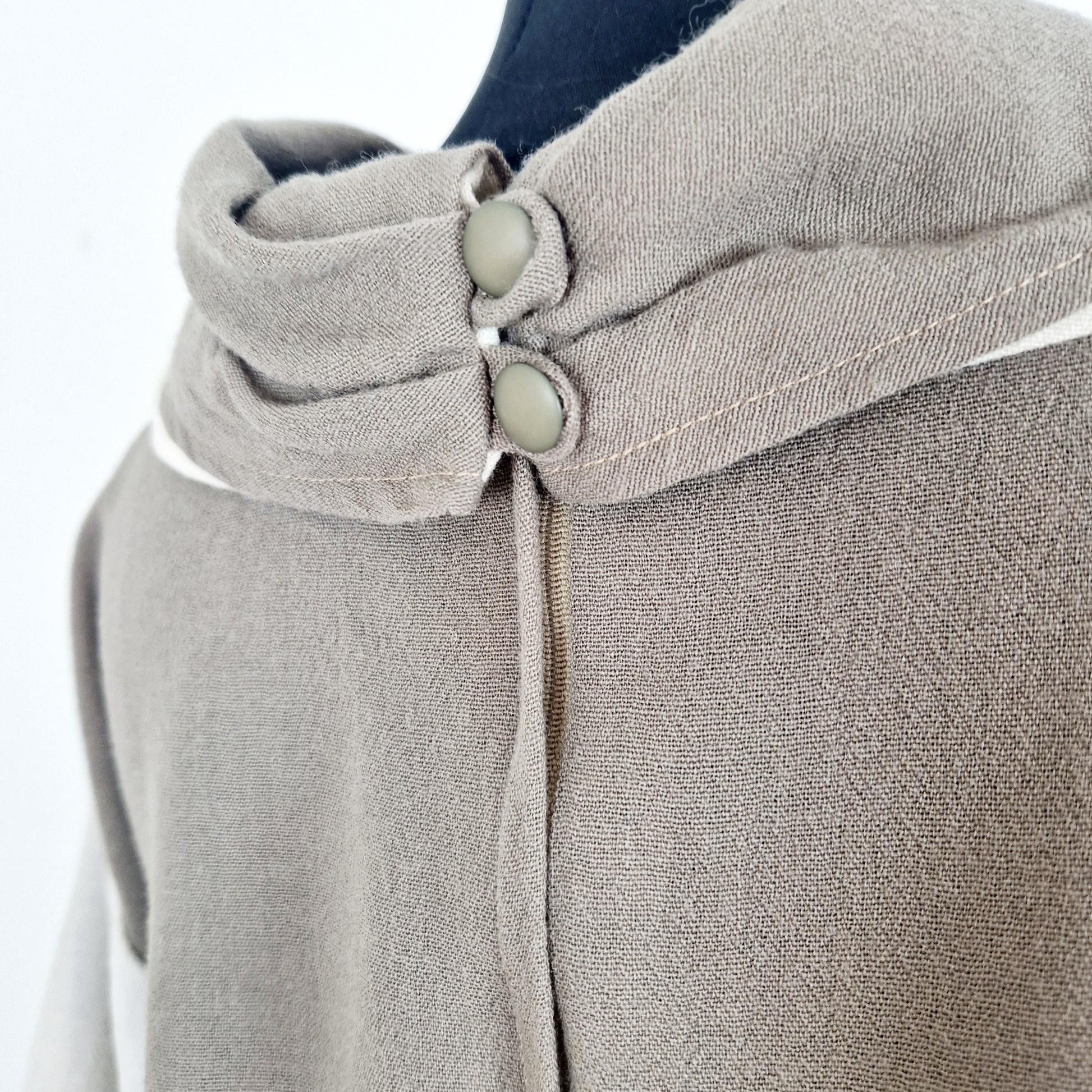 Einzigartiges und nachhaltiges Vintage Kleid in beige-Eierschale mit Kragen. Unique and sustainable vintage dress in brown-off-white with a collar. Close-up.