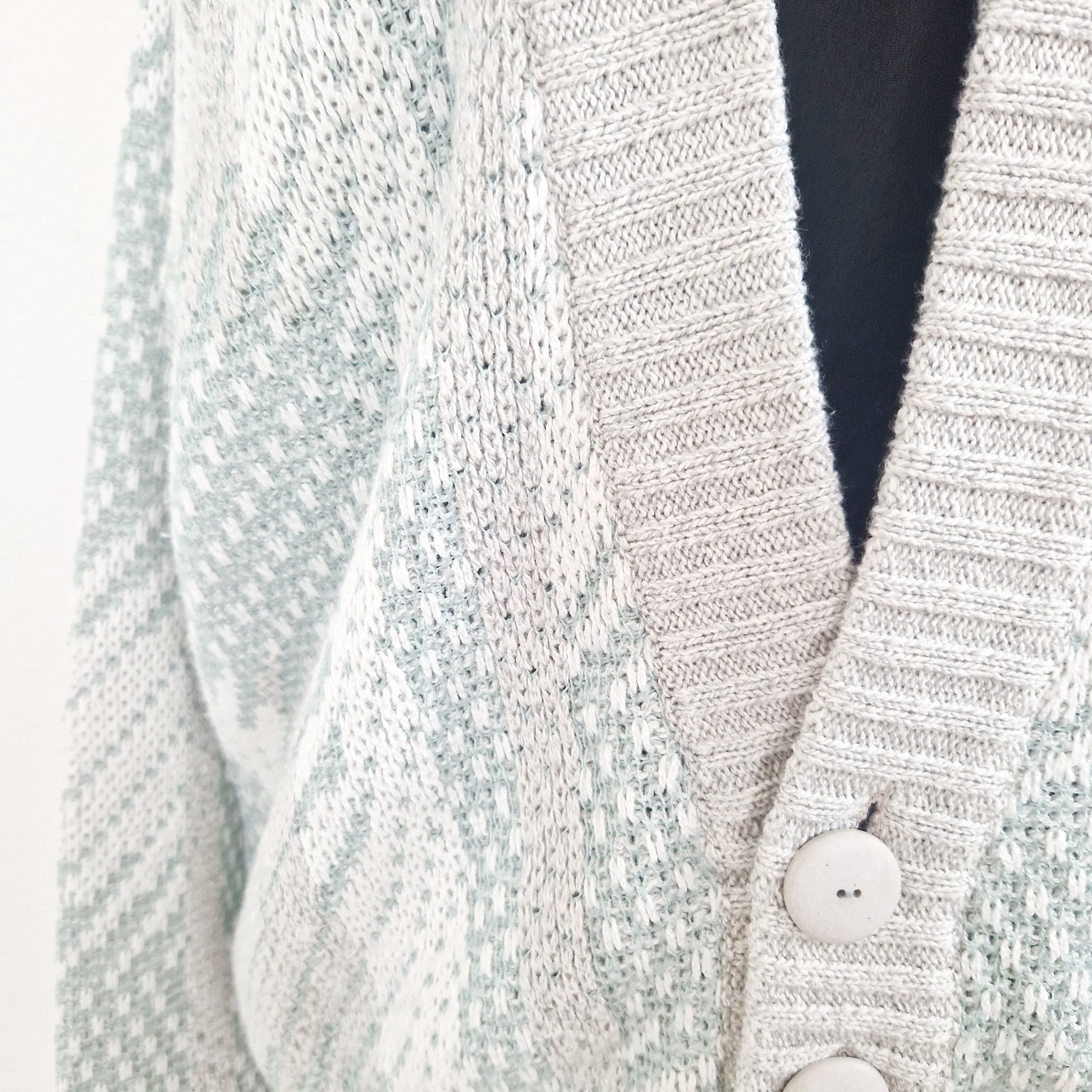 Einzigartiger und nachhaltiger Vintage Cardigan in hellgrau-mint. Unique and sustainable vintage cardigan in light grey-mint. Close-up.