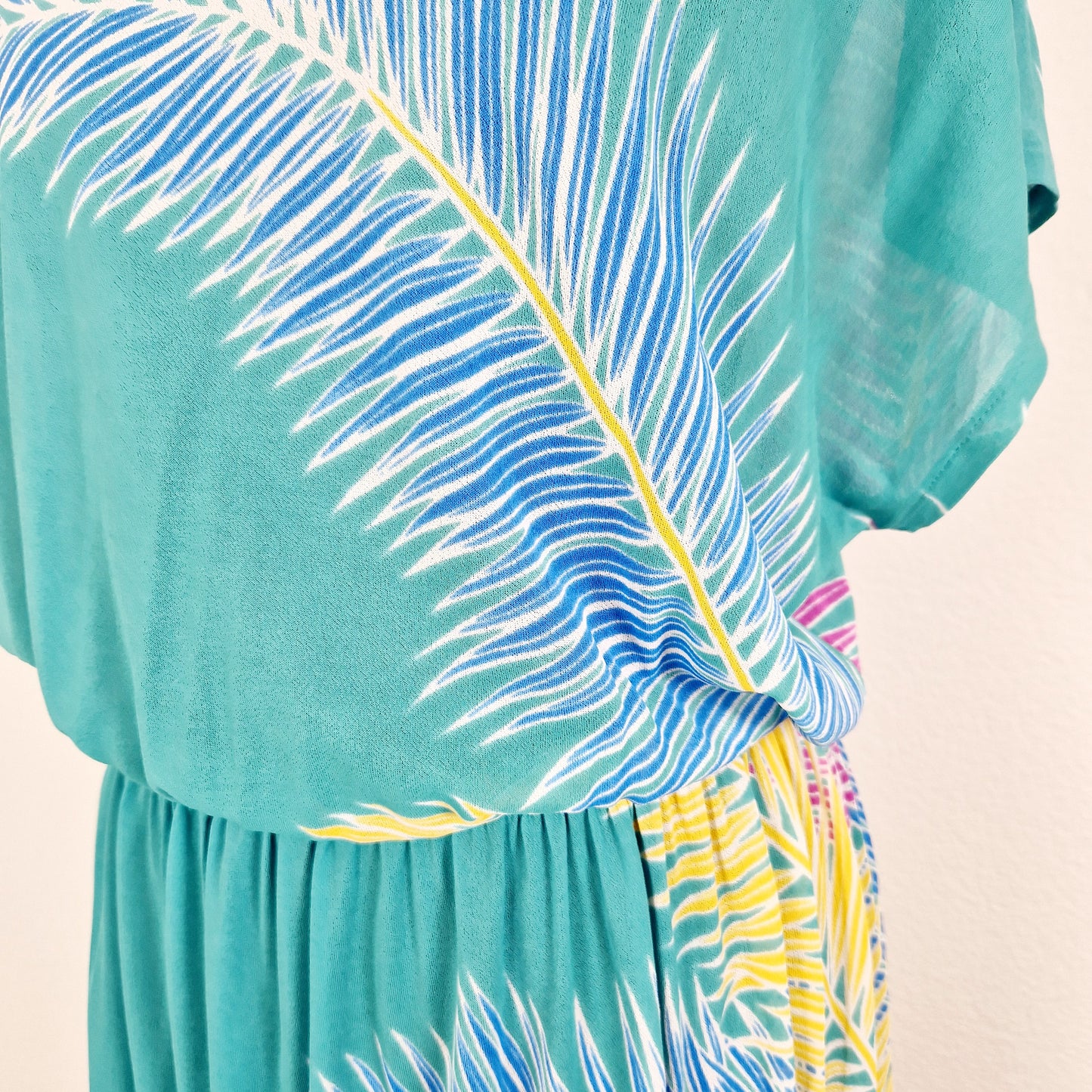 Einzigartiges und nachhaltiges Vintage Kleid in grün mit Palmen. Unique and sustainable vintage dress in green with palm trees. Close-up.