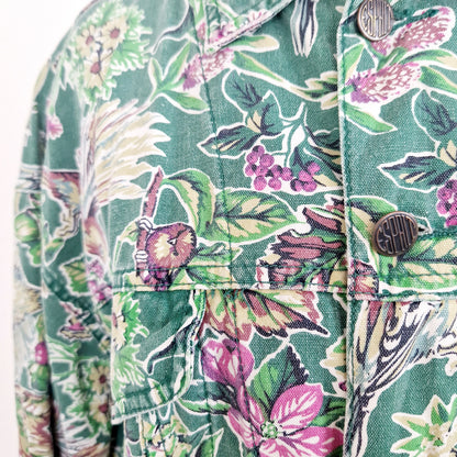 Einzigartige und nachhaltige Vintage Jacke in grün mit Blumen und Vögeln. Unique and sustainable vintage jacket in green with flowers and birds. Close-up.