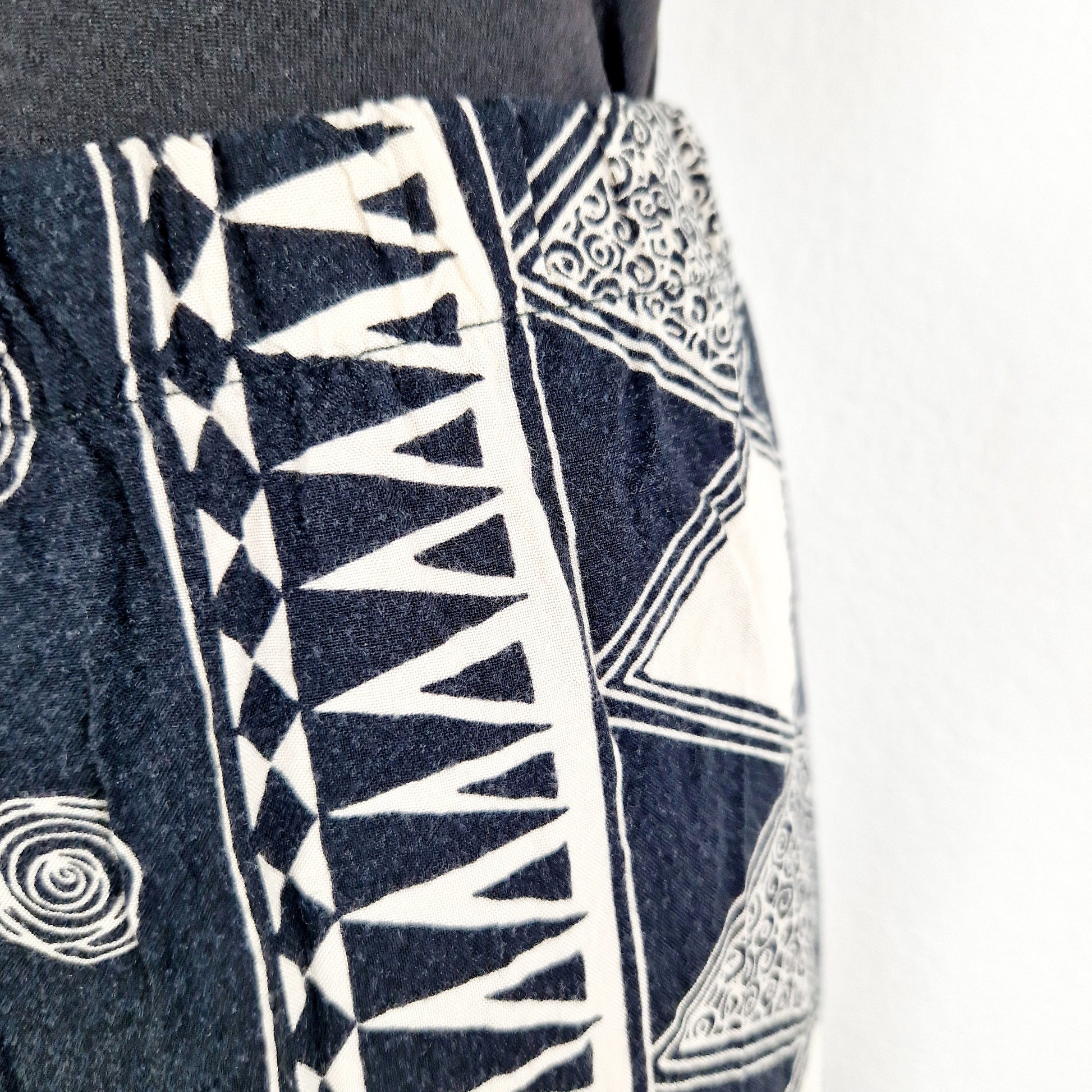 Einzigartige und nachhaltige Vintage Hose in schwarz-eierschale, geometrisich. Unique and sustainable vintage pants in black and off-white with geometric pattern. Close-up.