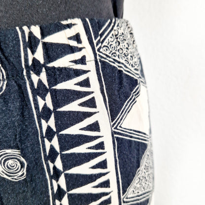 Einzigartige und nachhaltige Vintage Hose in schwarz-eierschale, geometrisich. Unique and sustainable vintage pants in black and off-white with geometric pattern. Close-up.