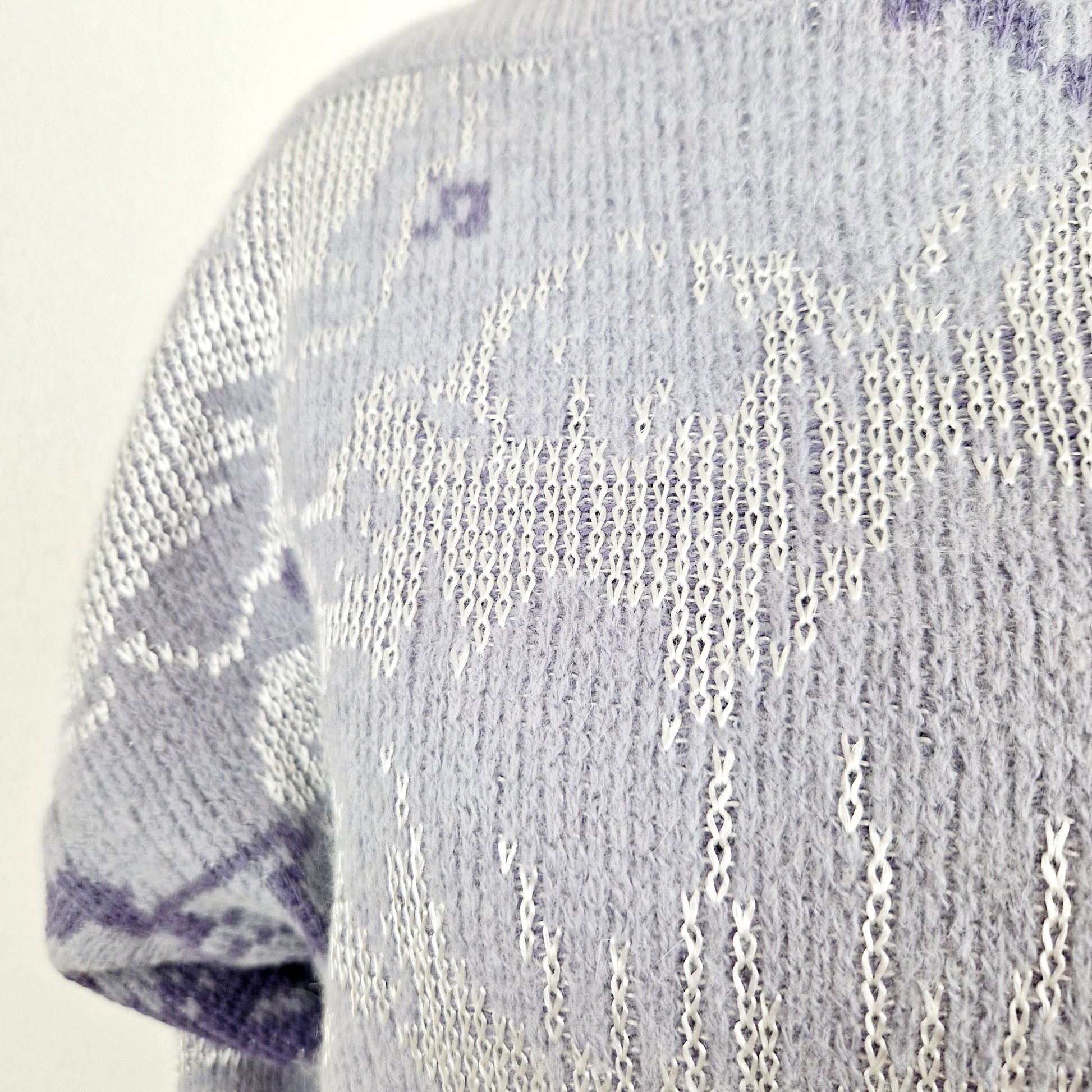 Einzigartiger und nachhaltiger Vintage Pullover in hellblau-silber. Unique and sustainable vintage pullover in light blue-silver. Close-up.