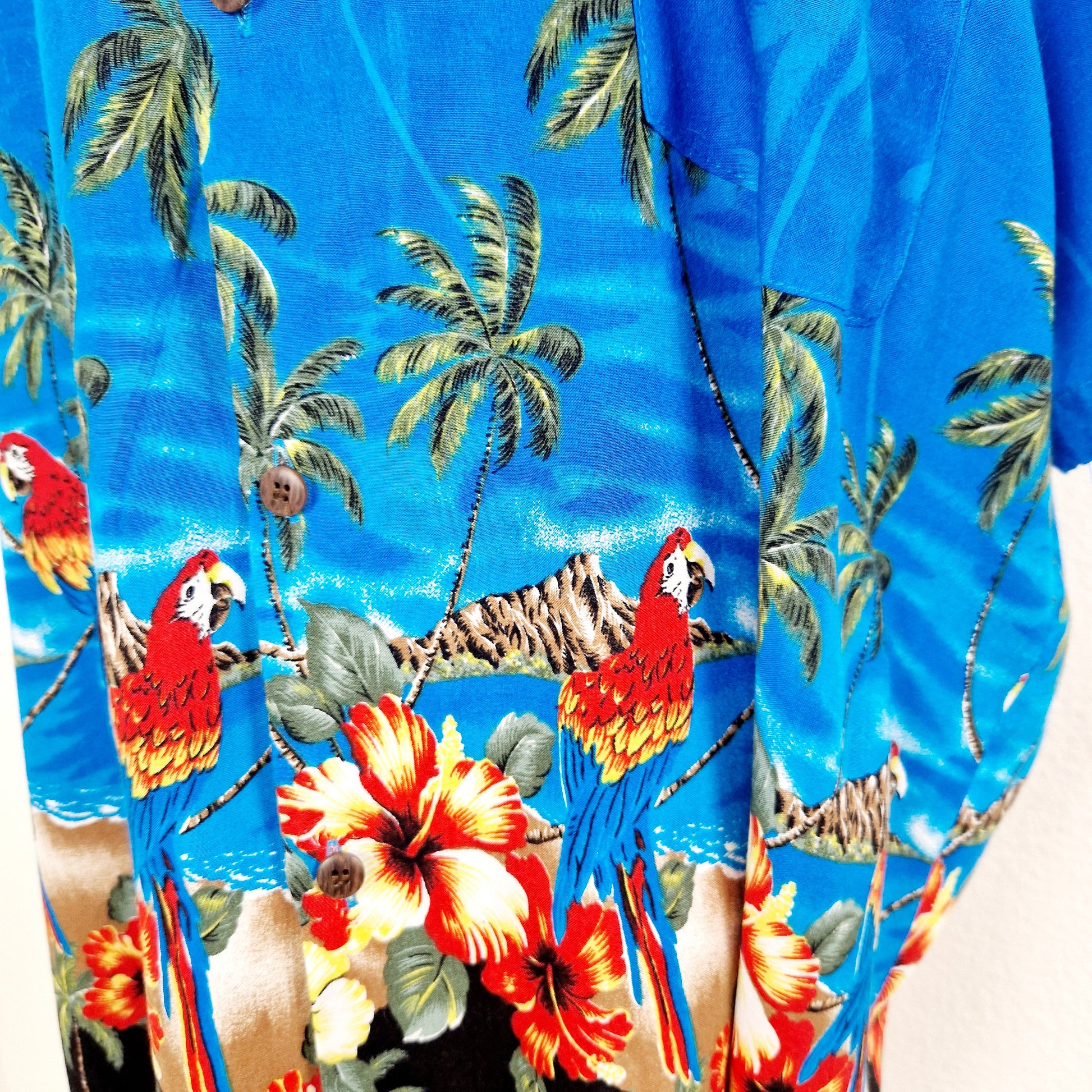 Einzigartiges und nachhaltiges Vintage Hemd in blau mit Papageien. Unique and sustainable vintage button-down in blue with parrots. Close-up.