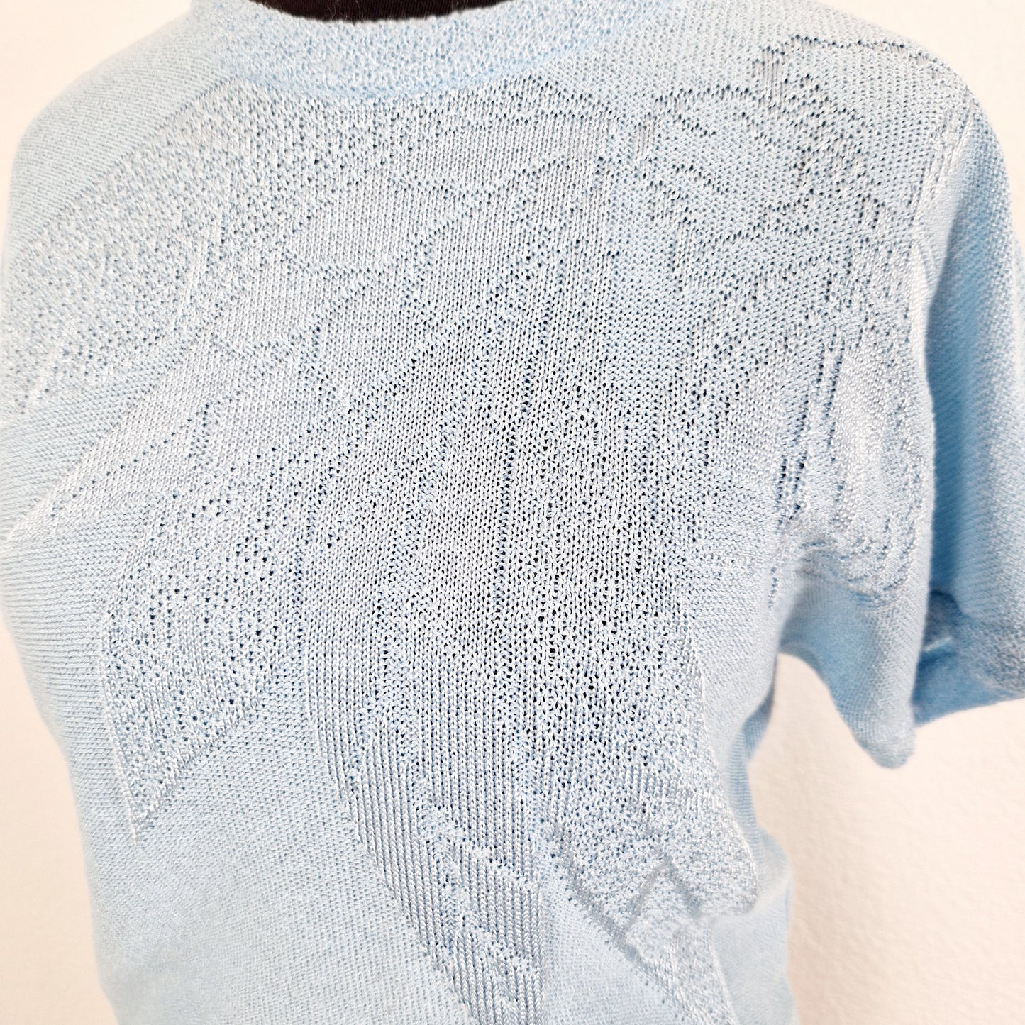 Einzigartiges und nachhaltiges Vintage T-Shirt in hellblau mit Blume. Unique and sustainable vintage t-shirt in light blue with flower. Close-up.