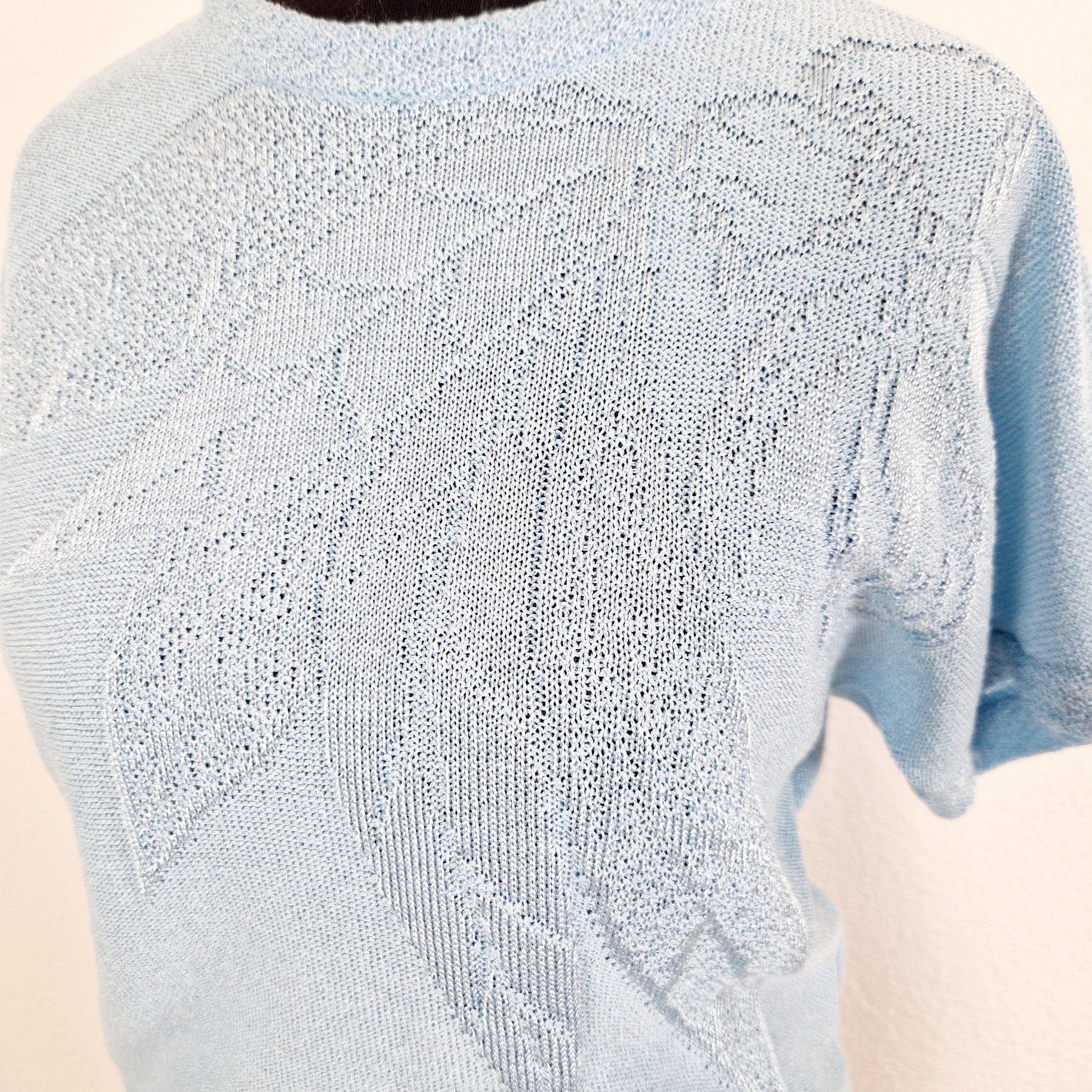 Einzigartiges und nachhaltiges Vintage T-Shirt in hellblau mit Blume. Unique and sustainable vintage t-shirt in light blue with flower. Close-up.
