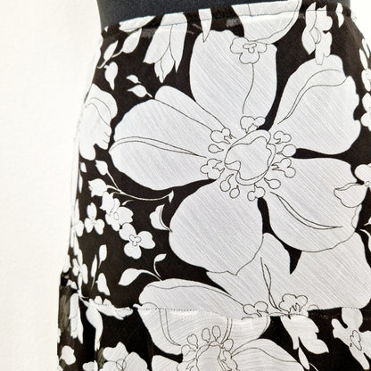Einzigartiger und nachhaltiger Vintage Rock in schwarz-weiss mit Blumen. Unique and sustainable vintage skirt in black and white with flowers. Close-up.